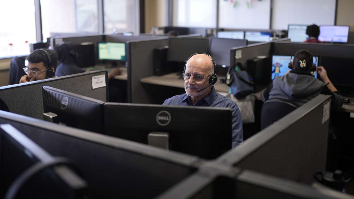Customer experience representatives Stanley Solis, center, and other representatives take calls at an Alorica center on Aug. 19, in San Antonio.