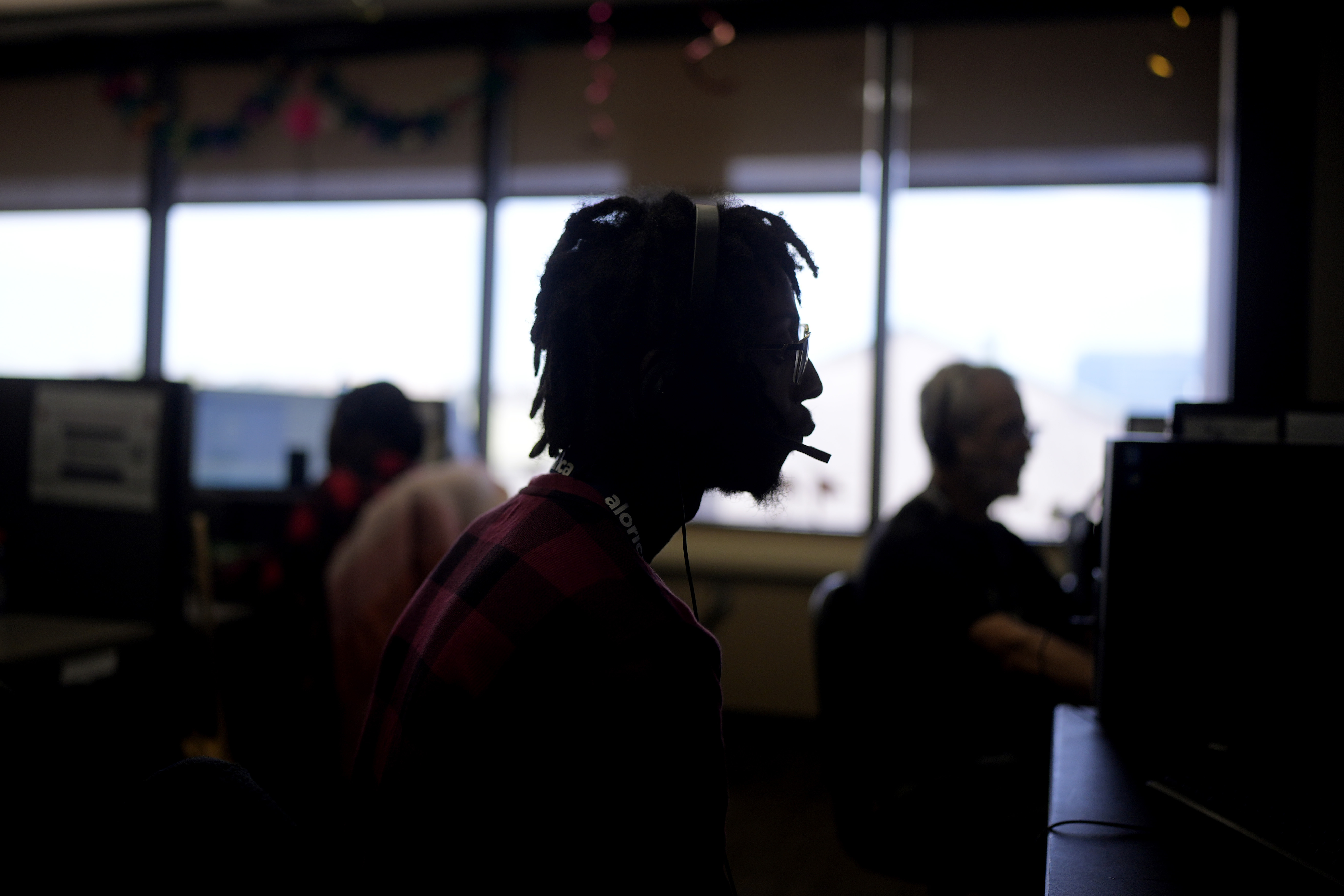 Customer Experience Representative Rico Thomas takes calls at an Alorica center on Aug. 19, in San Antonio, Texas.