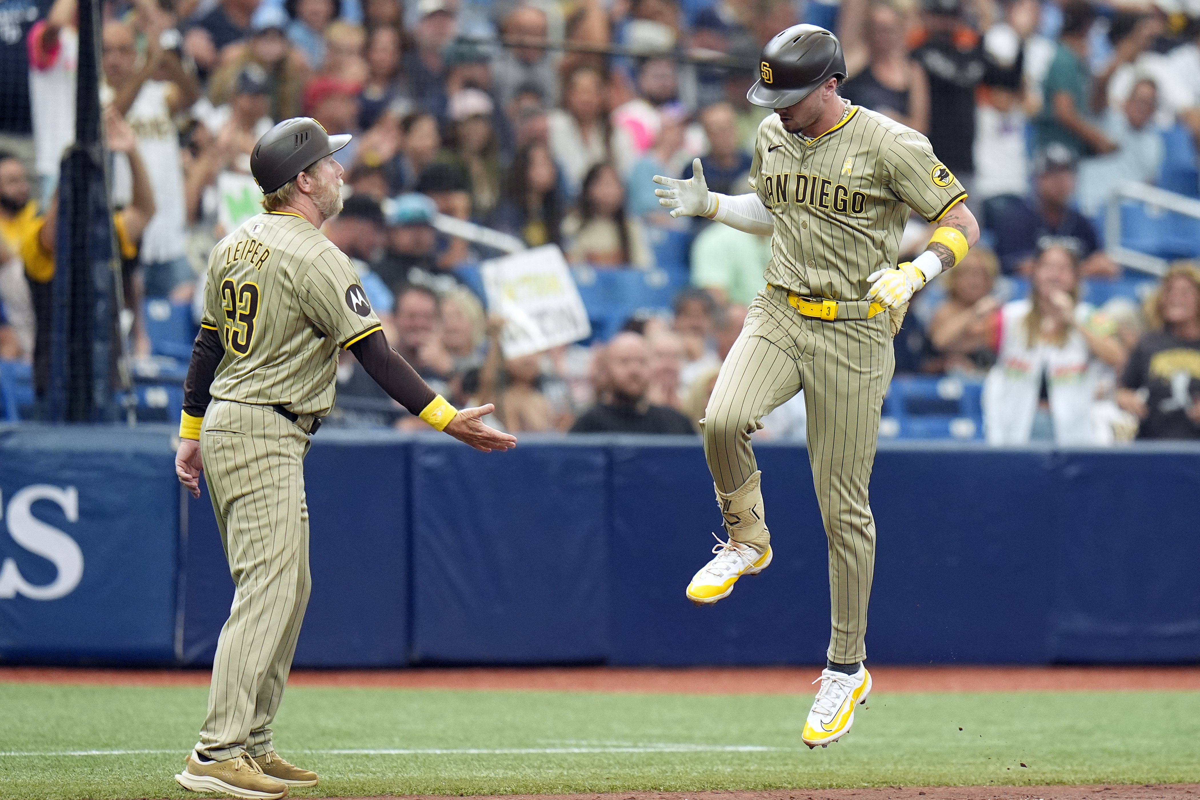 San Diego Padres' Jackson Merrill celebrates with third base coach Tim Leiper (33) after his two-run home run off Tampa Bay Rays starting pitcher Ryan Pepiot during the fourth inning of a baseball game Sunday, Sept. 1, 2024, in St. Petersburg, Fla.