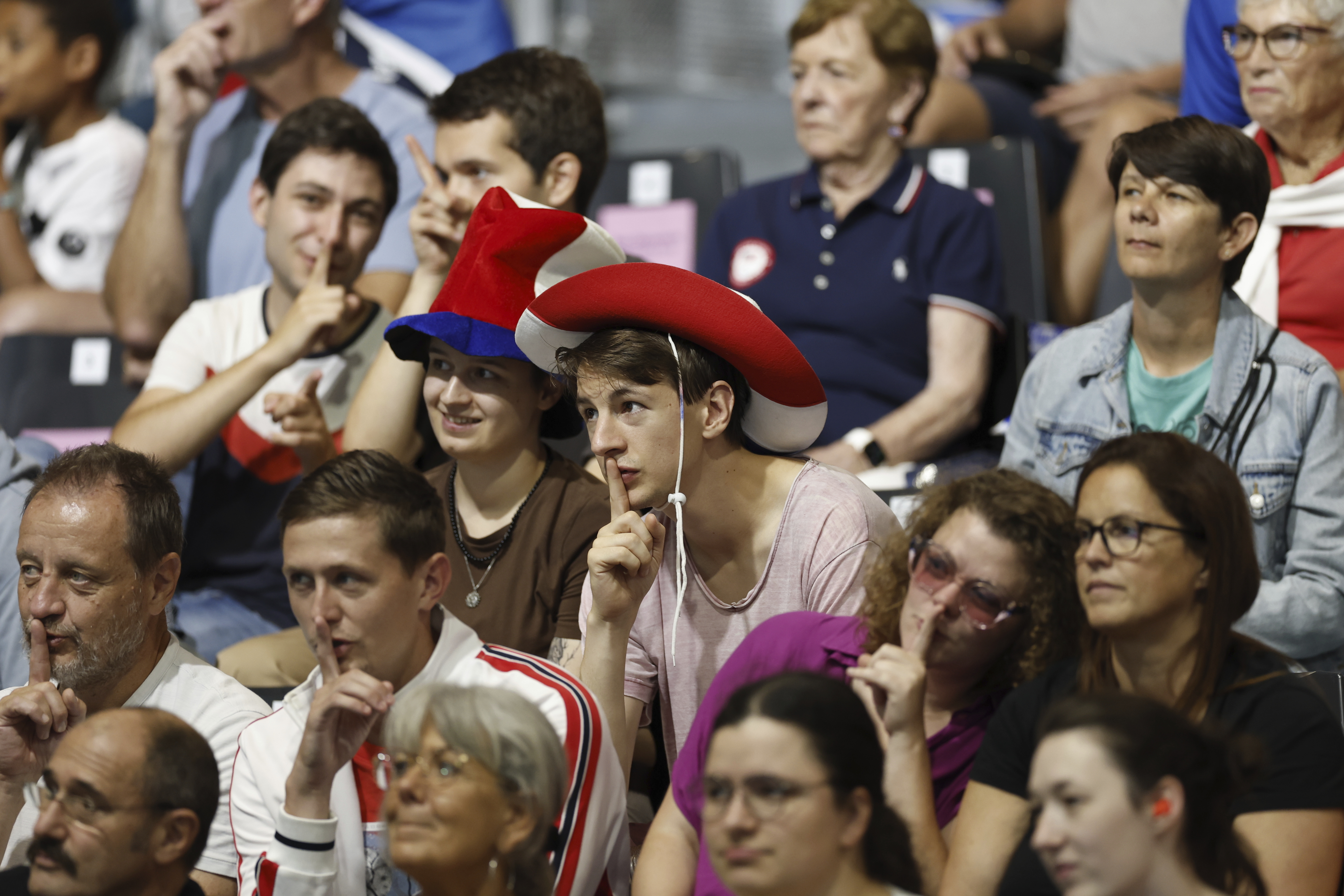 A group of fans shush the crowd as the "Shh Cam" scans the audience during the mens' United States versus France goalball game during the Paralympic Games in Paris on Saturday, Aug. 31, 2024. Football fans are known for being loud and rowdy. But the Paralympic sports most closely related to football, blind football and goalball, require spectators to be silent during game action so that players can receive audible cues from the ball and the environment. 