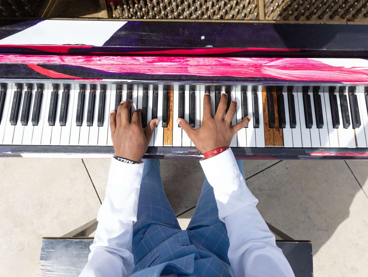 Ozi Fryer, 14, from Logan, plays on the pianos in front of Maurice Abravanel Hall in Salt Lake City on Aug. 4. Fryer said he has been playing piano for 10 years.