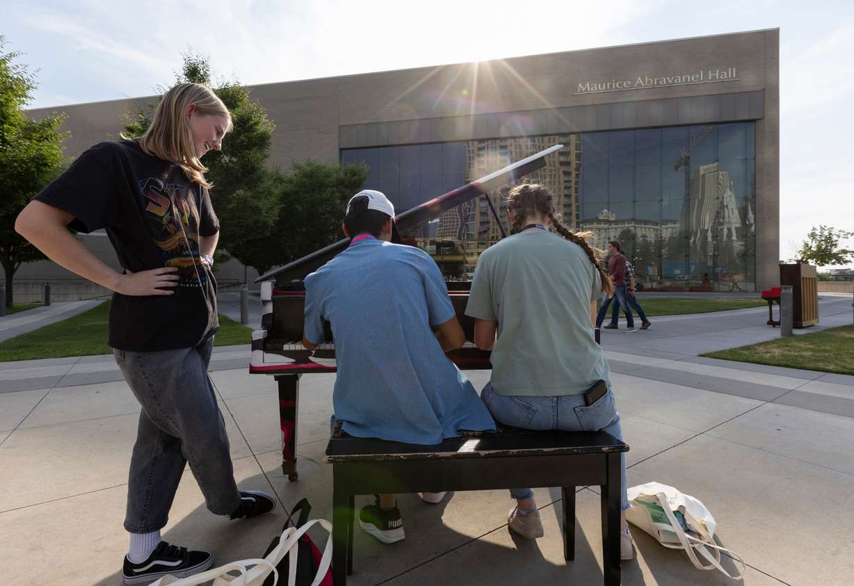 Sadie Porter, from Lehi, Seth Dobson, from Highland, and Brooklyn Copple, from Fairview, laugh together while they play one of the pianos in front of Maurice Abravanel Hall in Salt Lake City on Aug. 2. Porter said they were trying to play the theme from the movie "Interstellar."