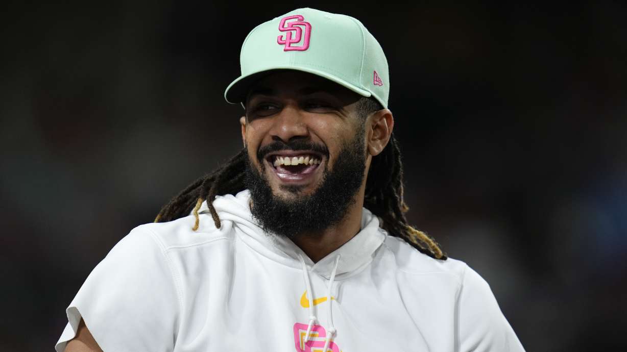 San Diego Padres's Fernando Tatis Jr. smiles in the dugout during the seventh inning of a baseball game against the New York Mets, Friday, Aug. 23, 2024, in San Diego.