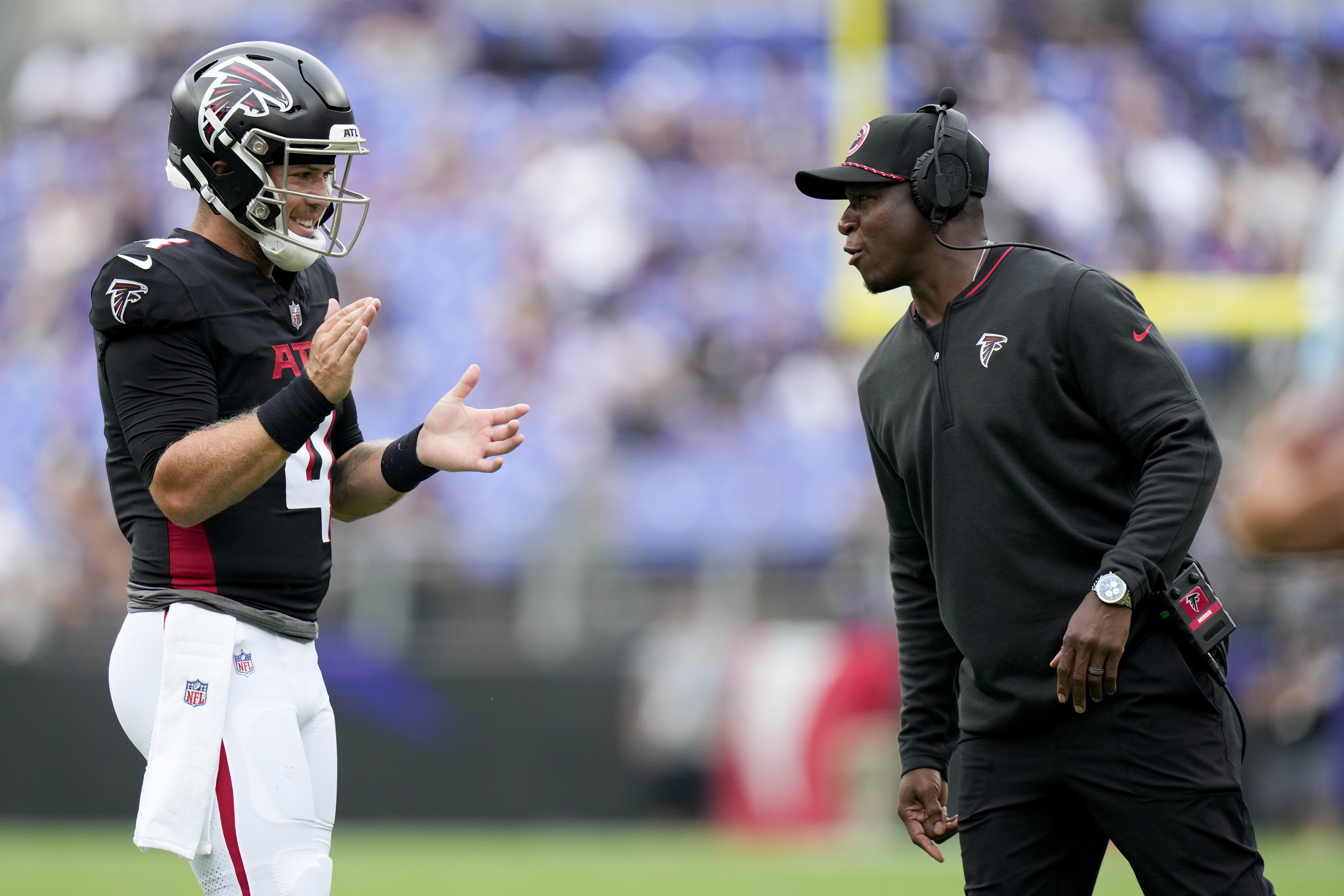 Atlanta Falcons quarterback Taylor Heinicke and head coach Raheem Morris meet on the sidelines during the first half of a preseason NFL football game against the Baltimore Ravens on Saturday, Aug. 17, 2024, in Baltimore. 