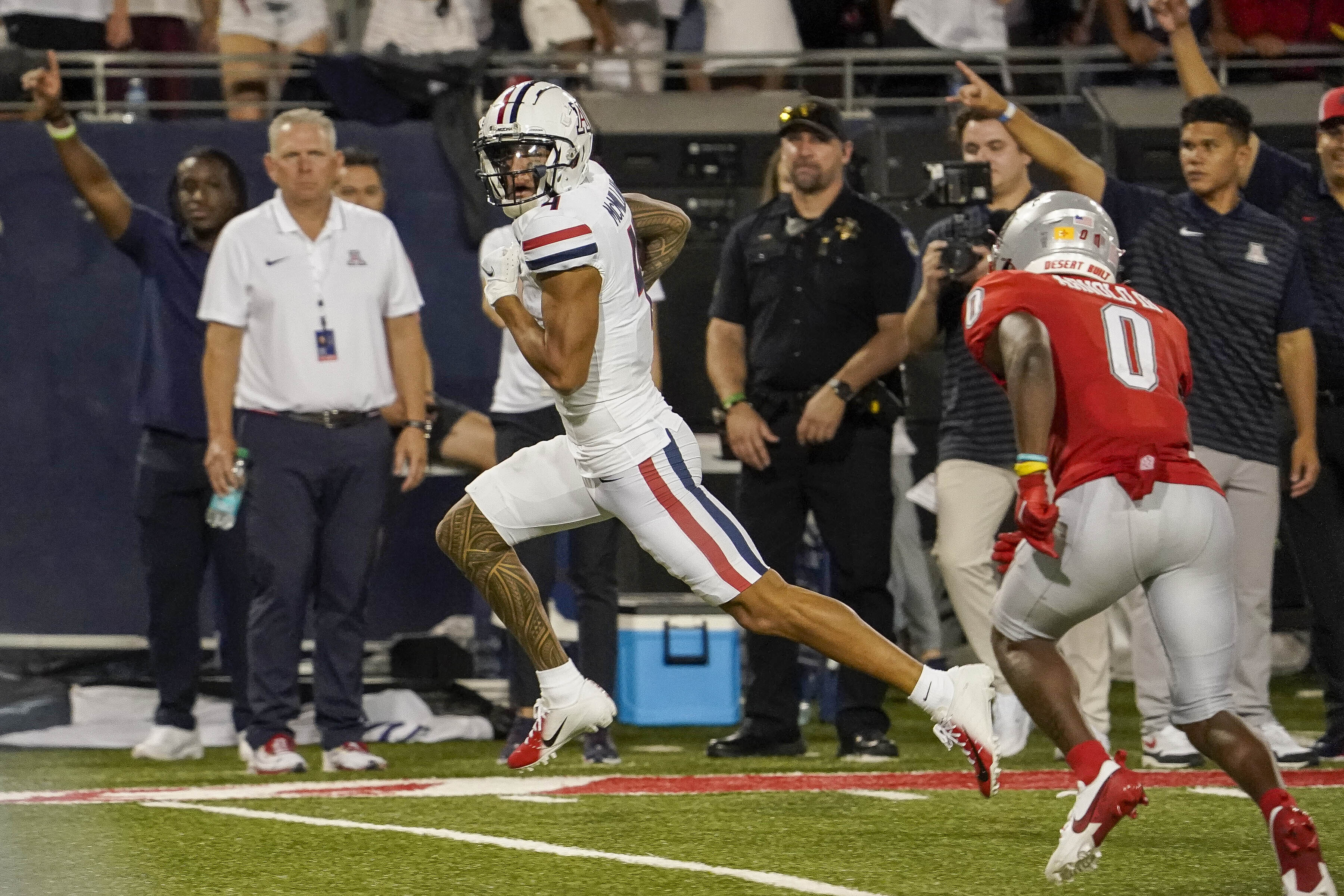 Arizona wide receiver Tetairoa McMillan, left, scores a touchdown as New Mexico cornerback Bobby Arnold III (0) pursues during the second half of an NCAA college football game Saturday, Aug. 31, 2024, in Tucson, Ariz. 