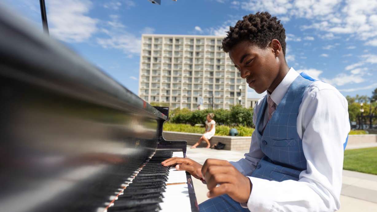Ozi Fryer, 14, from Logan, plays on the pianos in front of Maurice Abravanel Hall in Salt Lake City on Aug. 4. A project
features six upcycled pianos stationed outside Abravanel Hall that are open for the public to play through September.