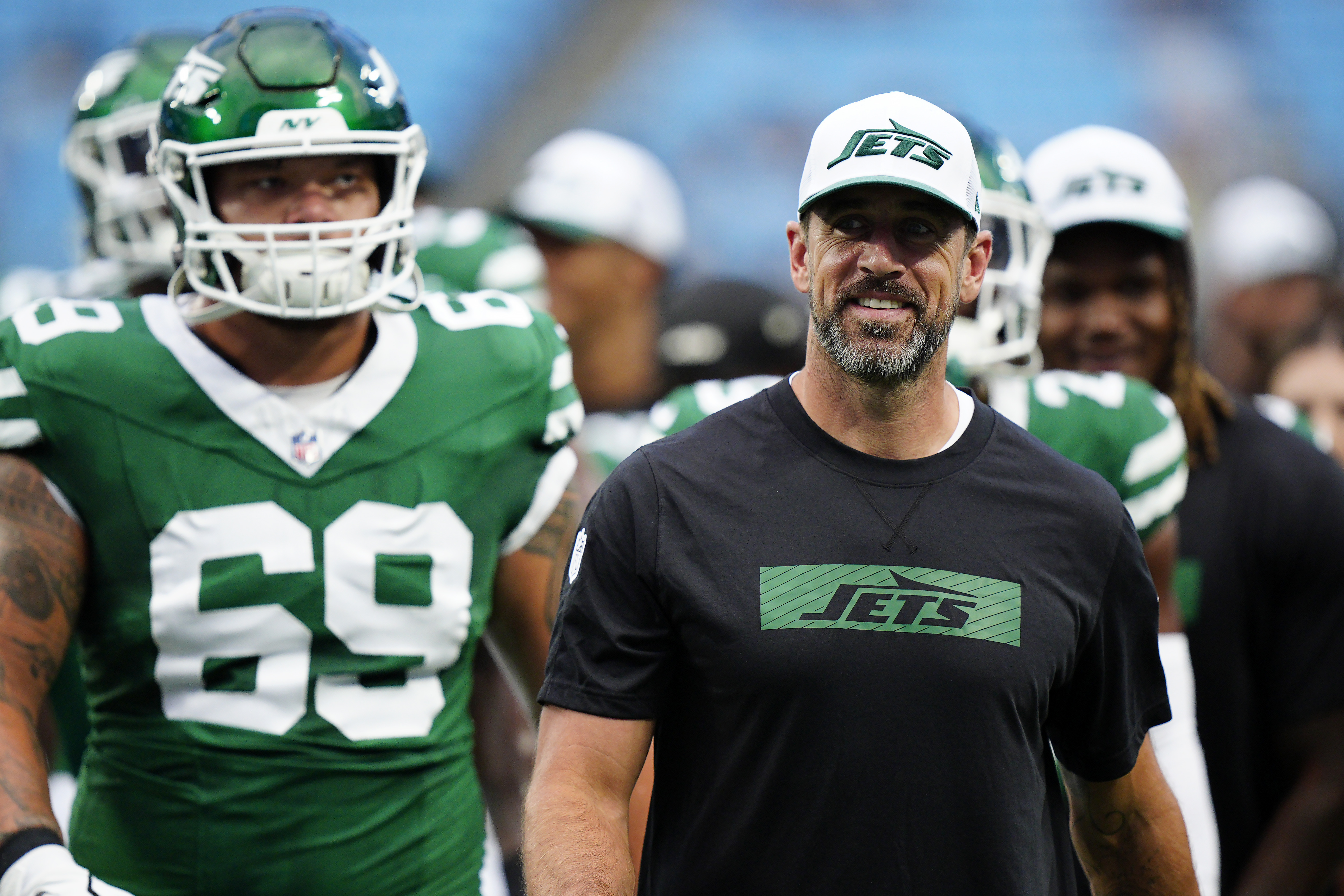 New York Jets quarterback Aaron Rodgers, right, walks on the field with teammates before a preseason NFL football game against the Carolina Panthers, Saturday, Aug. 17, 2024, in Charlotte, N.C. 