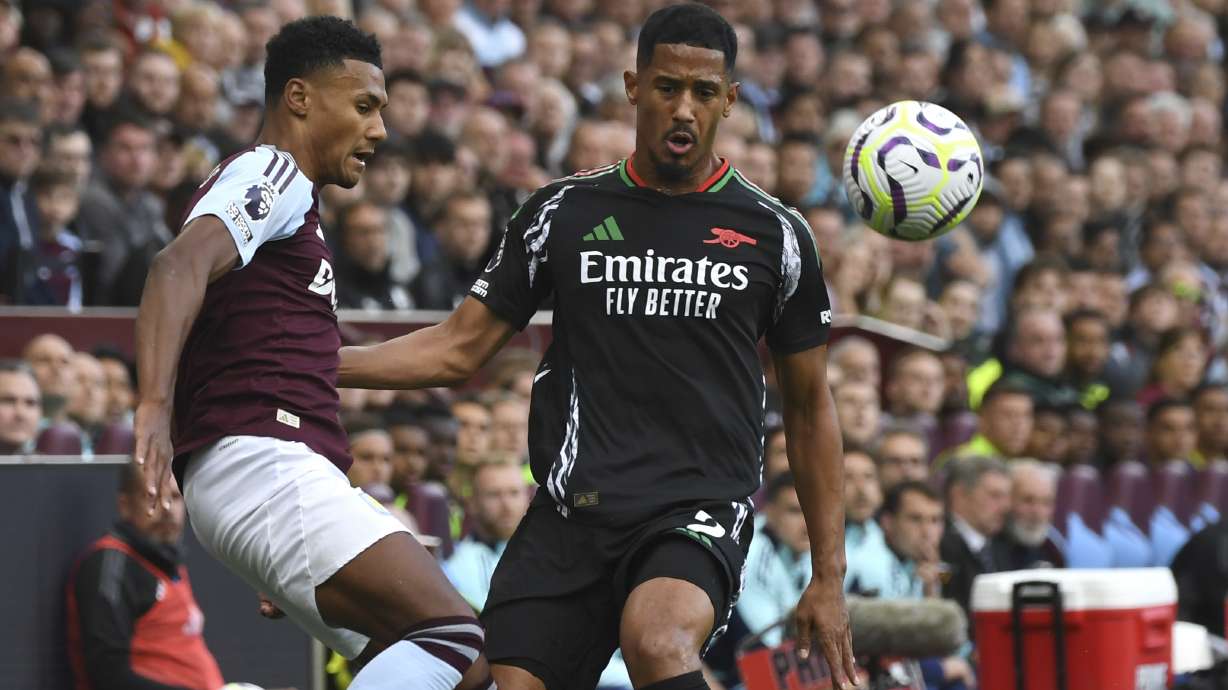 Aston Villa's Ollie Watkins, left, challenges for the ball with Arsenal's William Saliba during the English Premier League soccer match between Aston Villa and Arsenal at Villa Park in Birmingham, England, Saturday, Aug. 24, 2024.