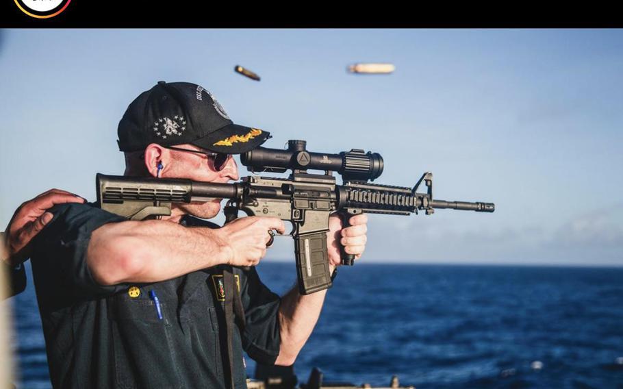 The commander of a Navy destroyer has been relieved of duty about four months after he was seen in this photo firing a rifle with a scope mounted backward.