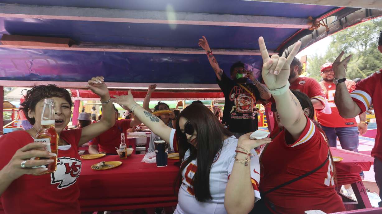 Kansas City Chiefs fans ride on "trajinera" boats along the water canals of Xochimilco in Mexico City, Sunday, Sept. 1, 2024, as they celebrate the arrival of a new NFL season.