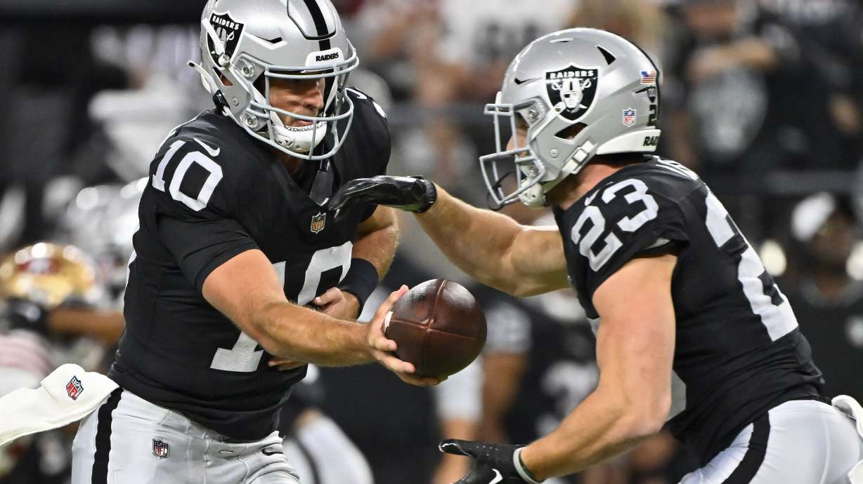 Las Vegas Raiders quarterback Nathan Peterman (10) hands off the ball to running back Dylan Laube (23) against the San Francisco 49ers during the first half of an NFL preseason football game, Friday, Aug. 23, 2024, in Las Vegas.