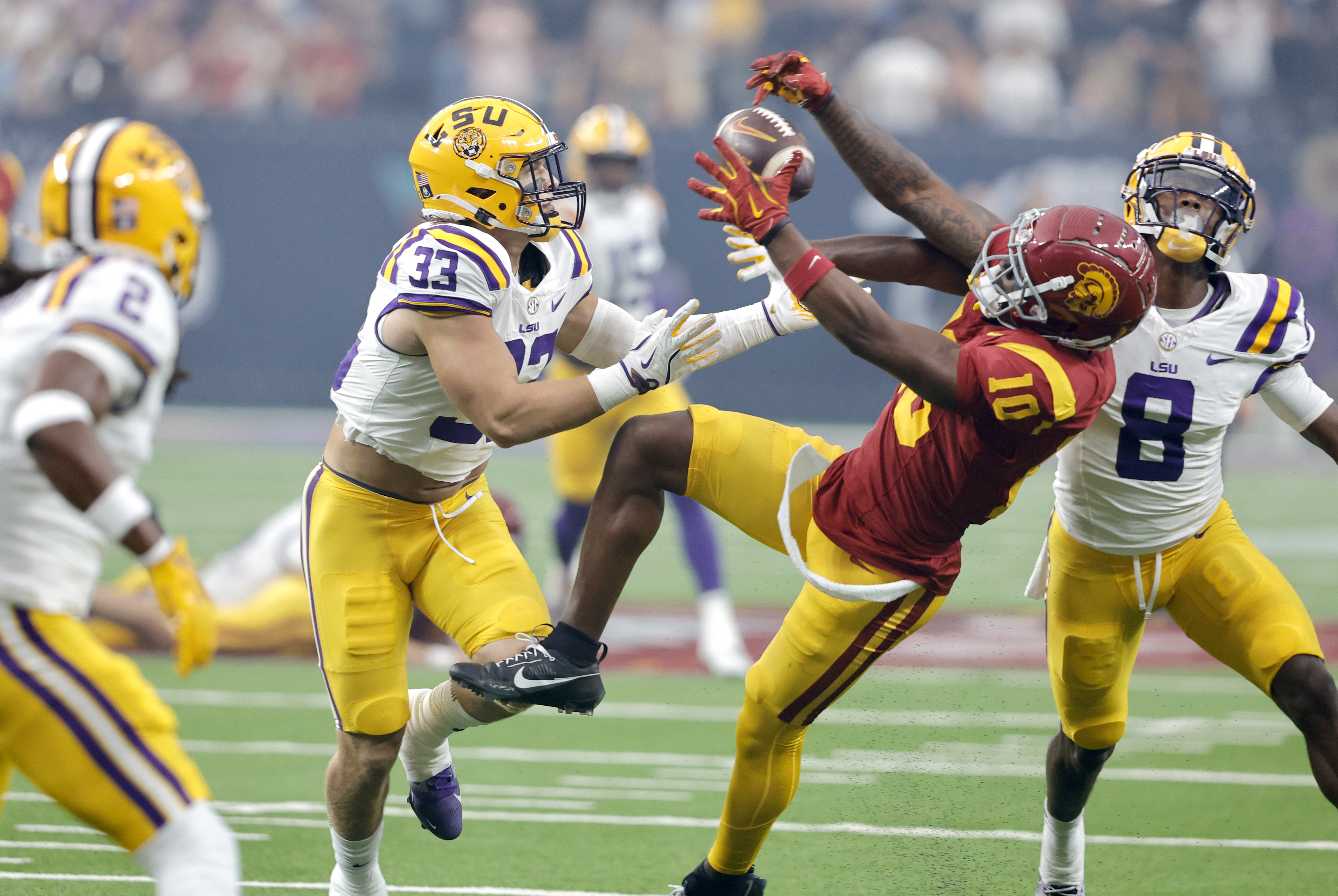 Southern California wide receiver Kyron Hudson (10) pulls in a pass between LSU linebacker West Weeks (33) and safety Major Burns (8) during the first half of an NCAA college football game Sunday, Sept. 1, 2024, in Las Vegas. 