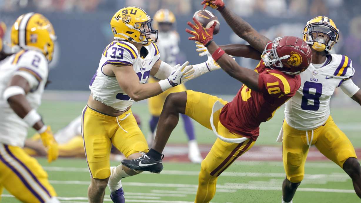 Southern California wide receiver Kyron Hudson (10) pulls in a pass between LSU linebacker West Weeks (33) and safety Major Burns (8) during the first half of an NCAA college football game Sunday, Sept. 1, 2024, in Las Vegas.