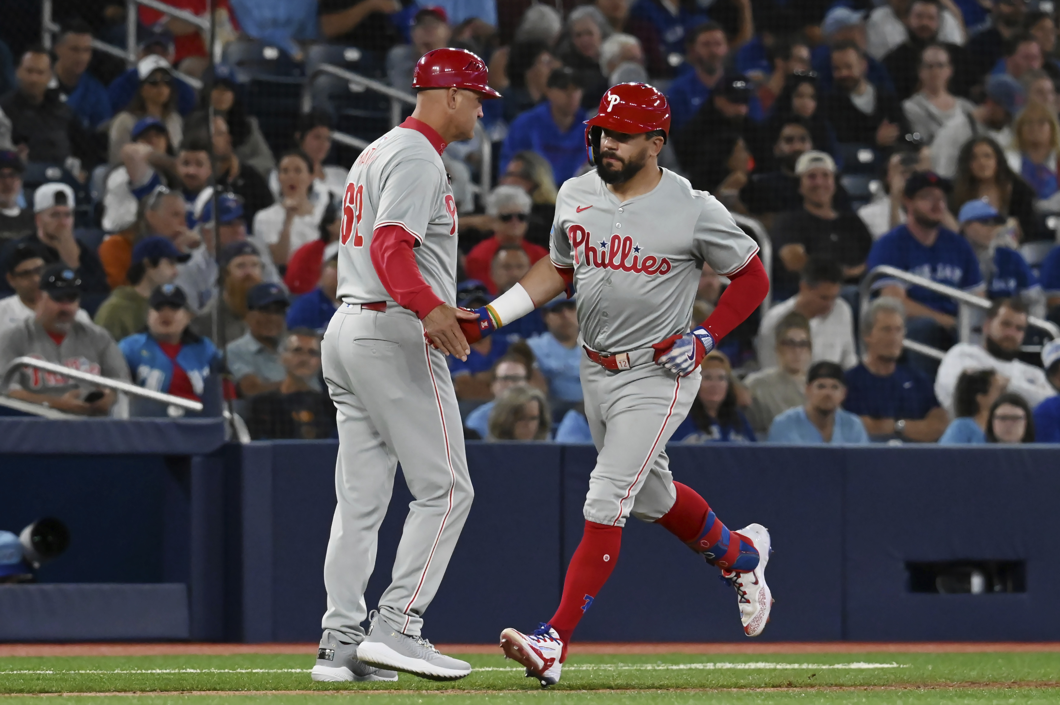 Philadelphia Phillies' Kyle Schwarber, right, celebrates with third base coach Dusty Wathan after hitting a solo home run in the fourth inning of a baseball game against the Toronto Blue Jays in Toronto on Tuesday Sept. 3, 2024. 