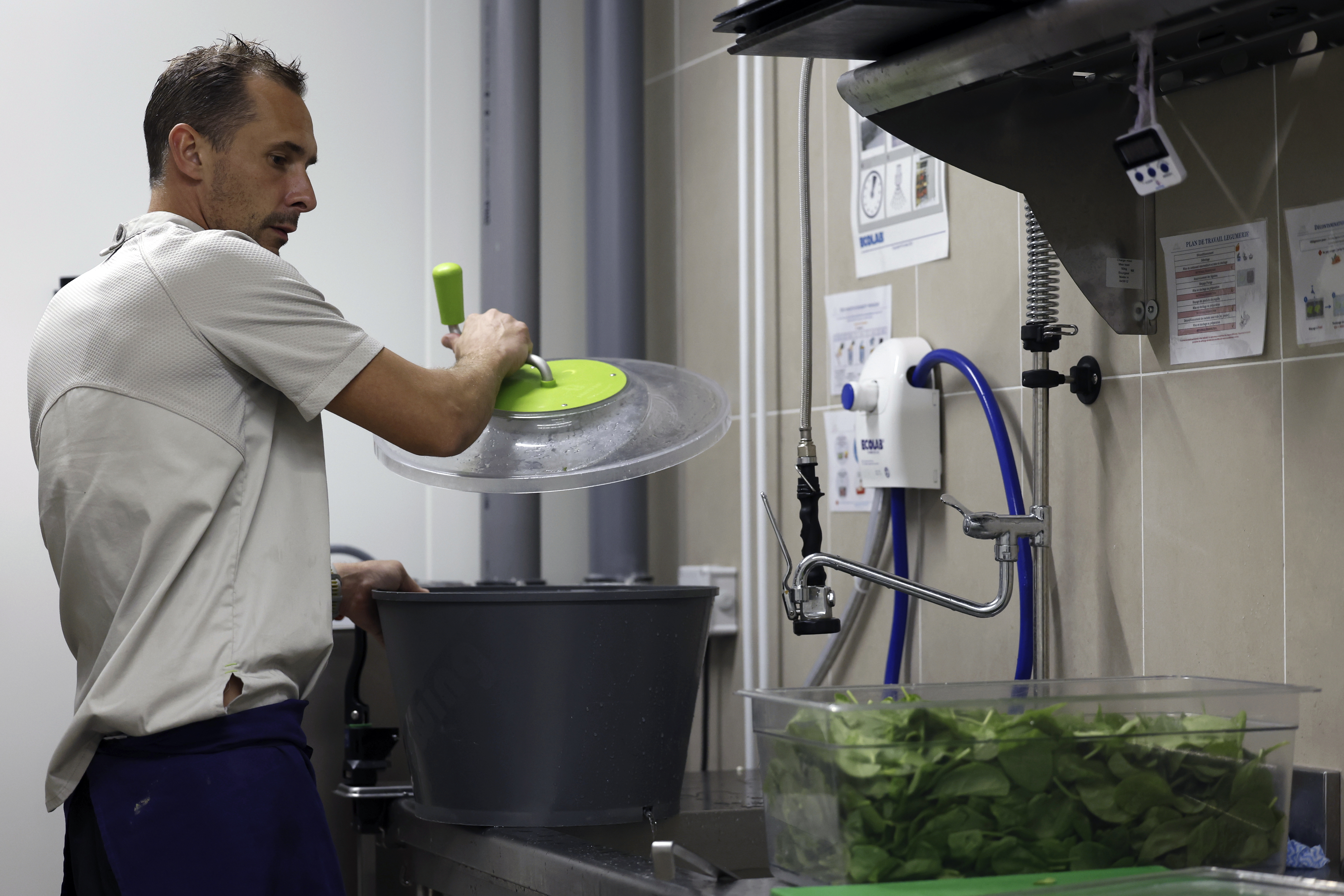 Pierre Bigot, a local sous chef, dries spinach in the kitchen of the United States Olympic and Paralympic Committee's High Performance Center's kitchen on Saturday, Aug. 31, 2024. The USOPC brought in staff from Colorado and also hired local chefs to work in the kitchen. 