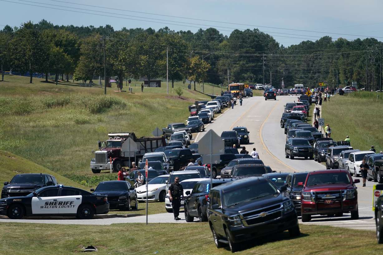 Cars are parked on the sides of a road as law enforcement officers work at the scene of a shooting at Apalachee High School in Winder, Ga., Wednesday.