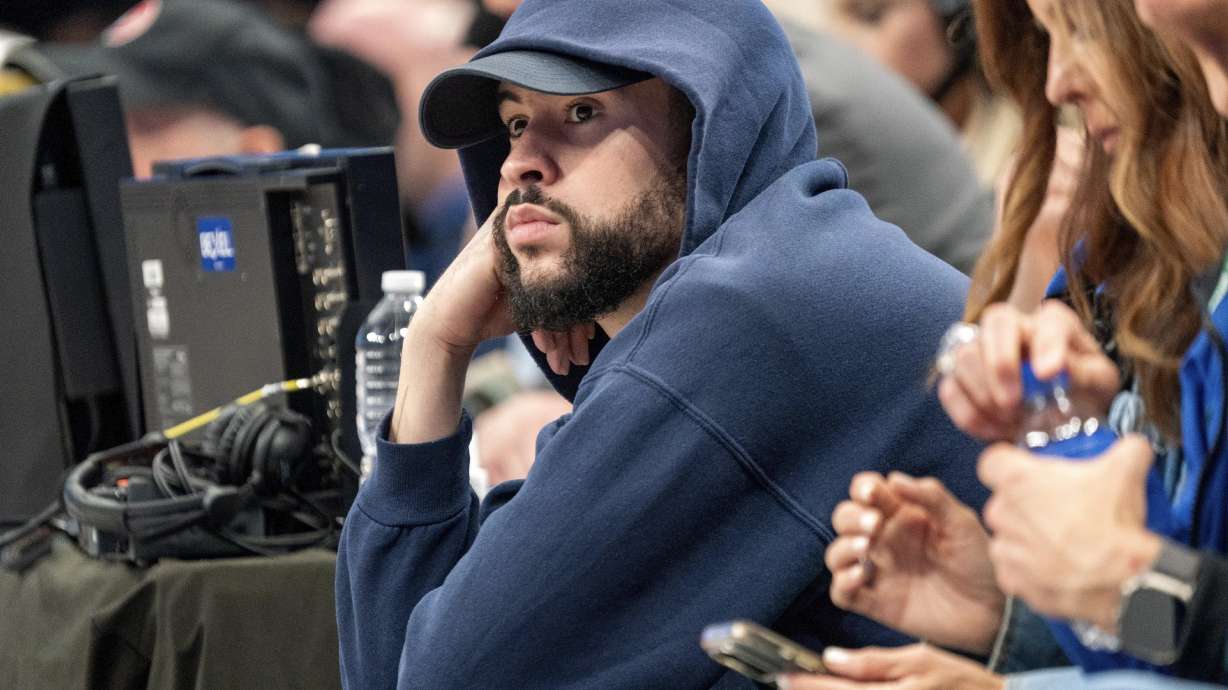 FILE - Puerto Rican recording artist Bad Bunny sits courtside during game 6 of an NBA basketball first-round playoff series between the Dallas Mavericks and the Los Angeles Clippers Friday, May 3, 2024, in Dallas. A federal judge halted a lawsuit by Bad Bunny’s sports representation firm against the Major League Baseball Players Association, ruling Thursday, AUg. 15, 2024, the case should be heard by an arbitrator.
