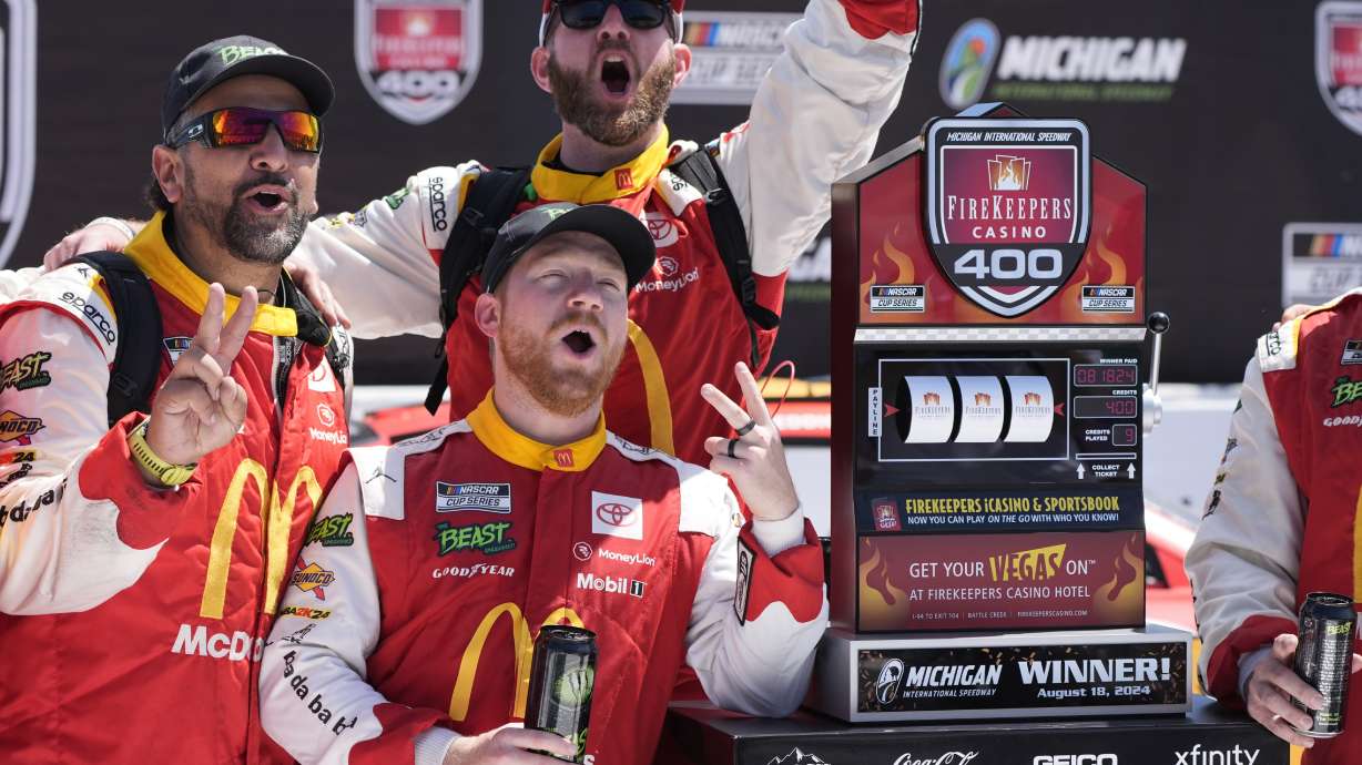 Tyler Reddick and crew stand by the winner's trophy after a NASCAR Cup Series auto race at Michigan International Speedway, Monday, Aug. 19, 2024, in Brooklyn, Mich.