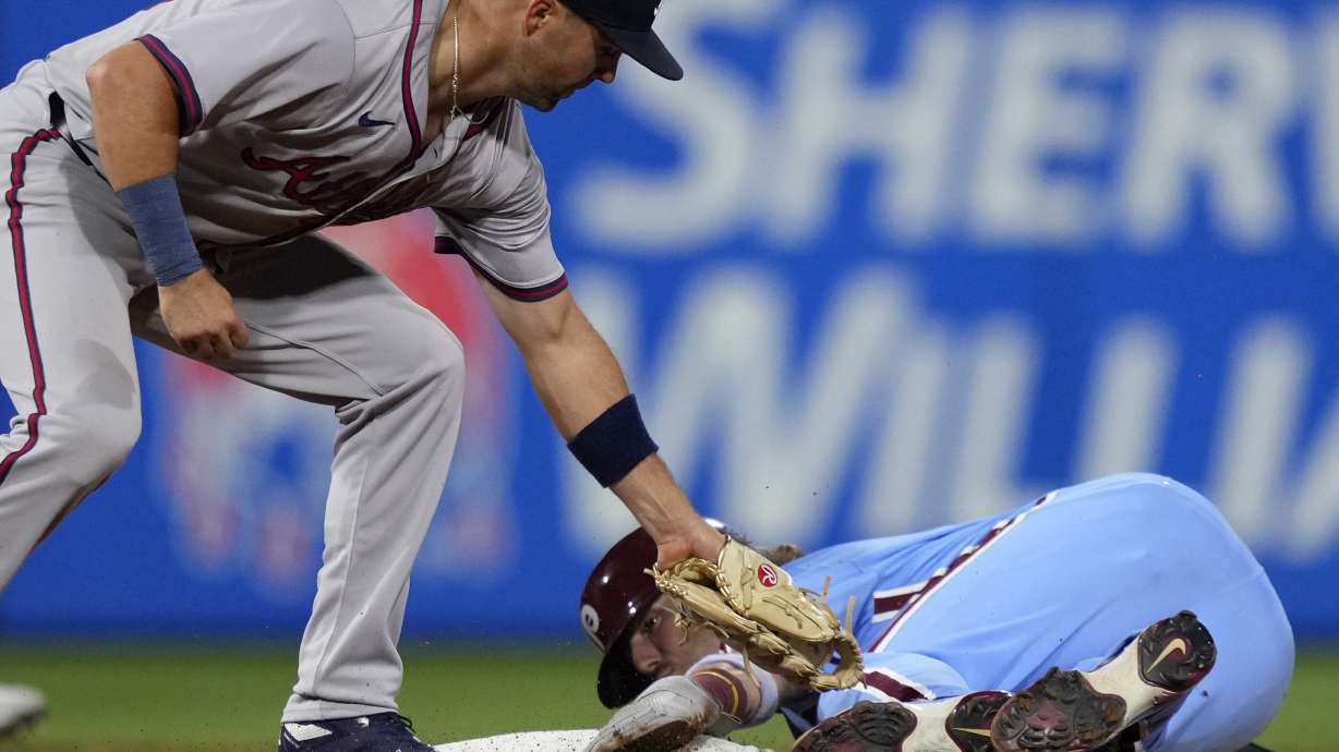 Philadelphia Phillies' Bryson Stott, right, steals second past Atlanta Braves second baseman Whit Merrifield during the fourth inning of a baseball game, Thursday, Aug. 29, 2024, in Philadelphia.
