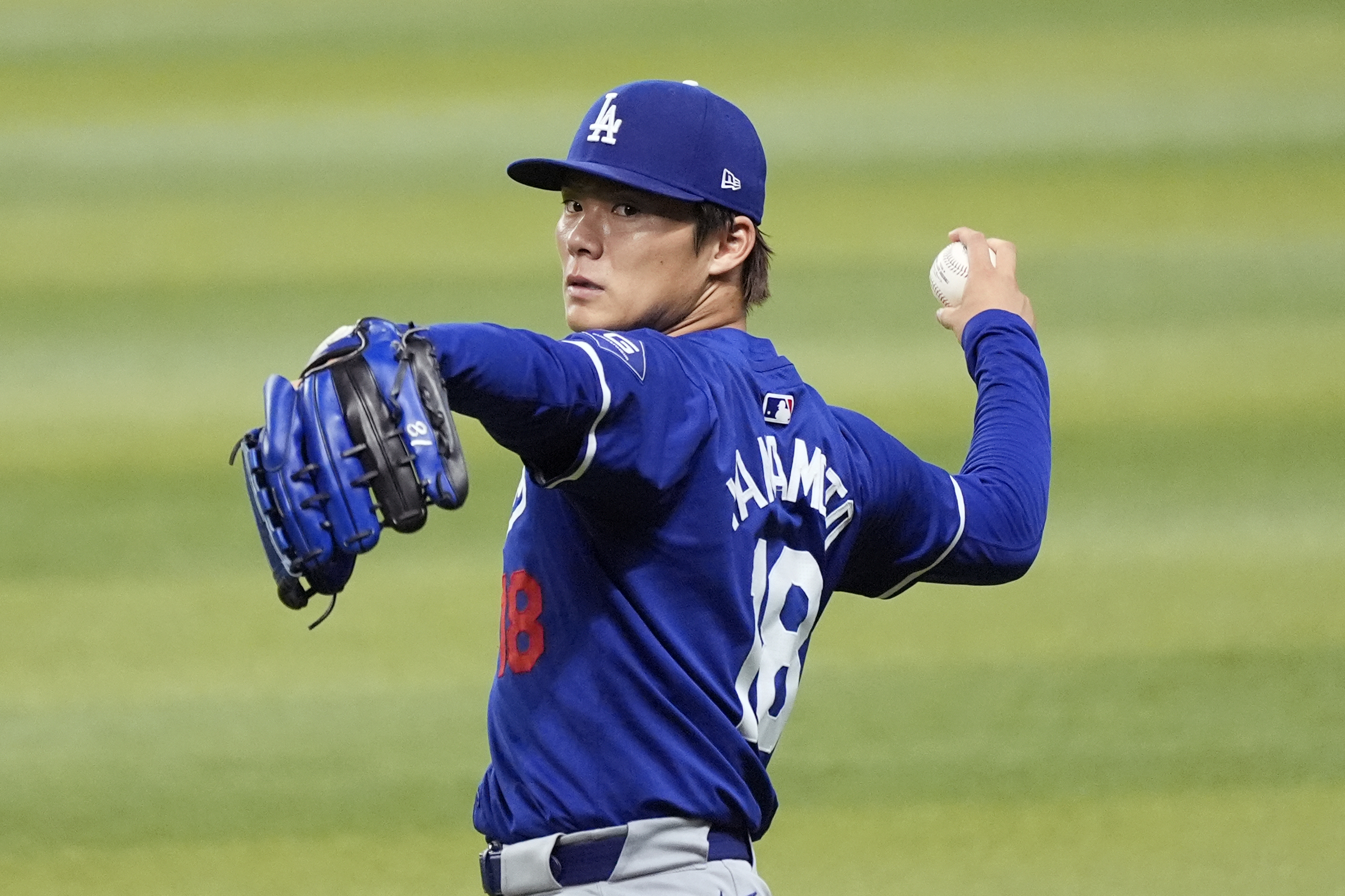 Injured Los Angeles Dodgers starting pitcher Yoshinobu Yamamoto, of Japan, warms up prior to a baseball game against the Arizona Diamondbacks, Sunday, Sept. 1, 2024, in Phoenix.