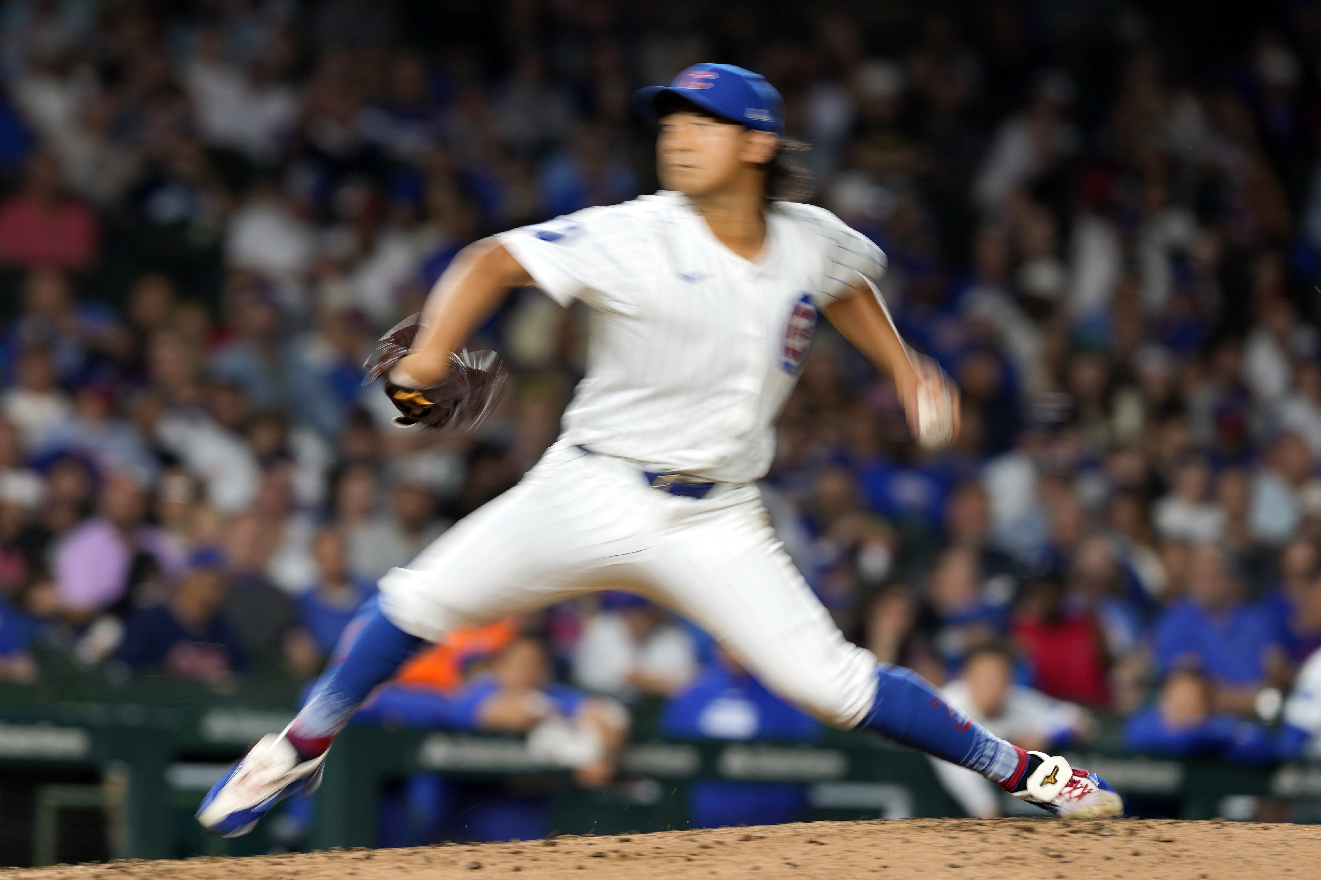 In this image taken with a slow shutter speed, Chicago Cubs pitcher Shota Imanaga throws during the fifth inning of a baseball game against the Pittsburgh Pirates on Wednesday, Sept. 4, 2024, in Chicago. 