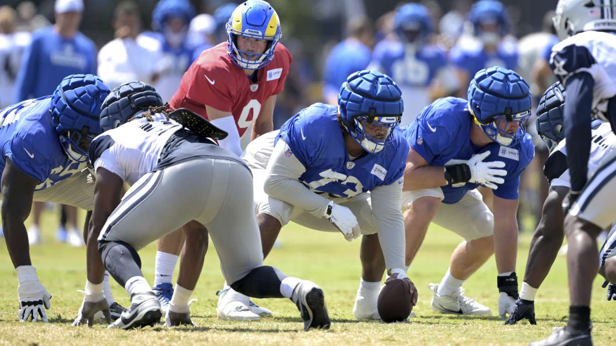Los Angeles Rams quarterback Matthew Stafford (9) takes the snap from center Steve Avila during a joint practice with the Dallas Cowboys at the Cowboy's NFL football training camp Thursday, Aug. 8, 2024, in Oxnard, Calif.