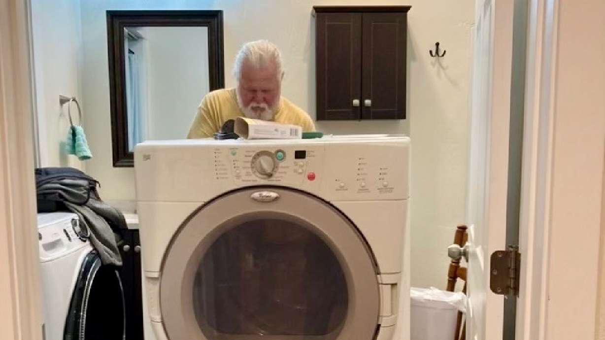 Sam Thomas, part of a Morgan County group that helped a family of South American refugees resettle in Utah, assists in preparing the new home where they moved.