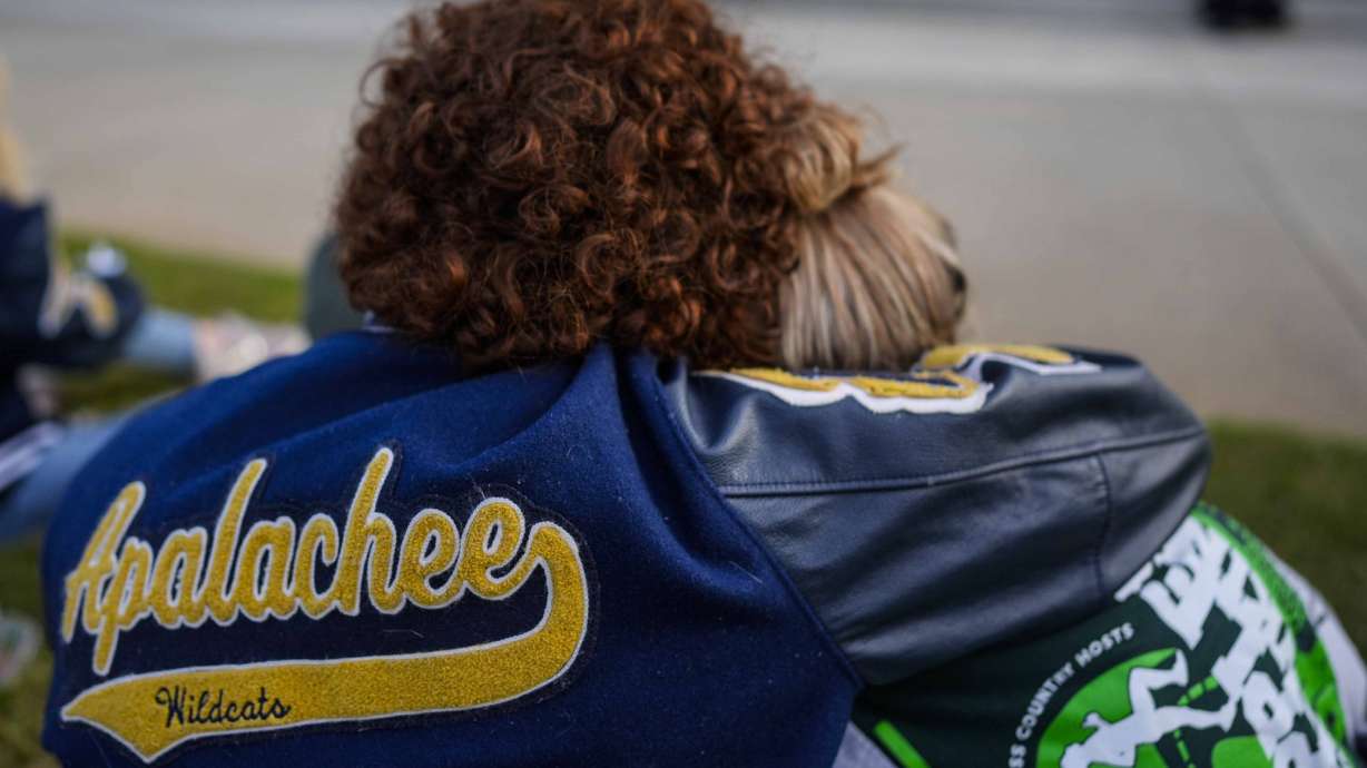 Mourners listen to a speaker during a candlelight vigil for the slain students and teachers at Apalachee High School, Wednesday, in Winder, Ga. Authorities say the father of the teen charged with opening fire at the school has been arrested on charges including second-degree murder and involuntary manslaughter.