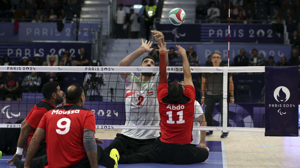 Iran's Morteza Mehrzadselakjani, number 2, attempts to block the ball from Egypt's Zakareia Abdo during the semifinal of the men's sitting volleyball at the North Paris Arena at the 2024 Paralympics in Pars, Thursday, Sept. 5, 2024.