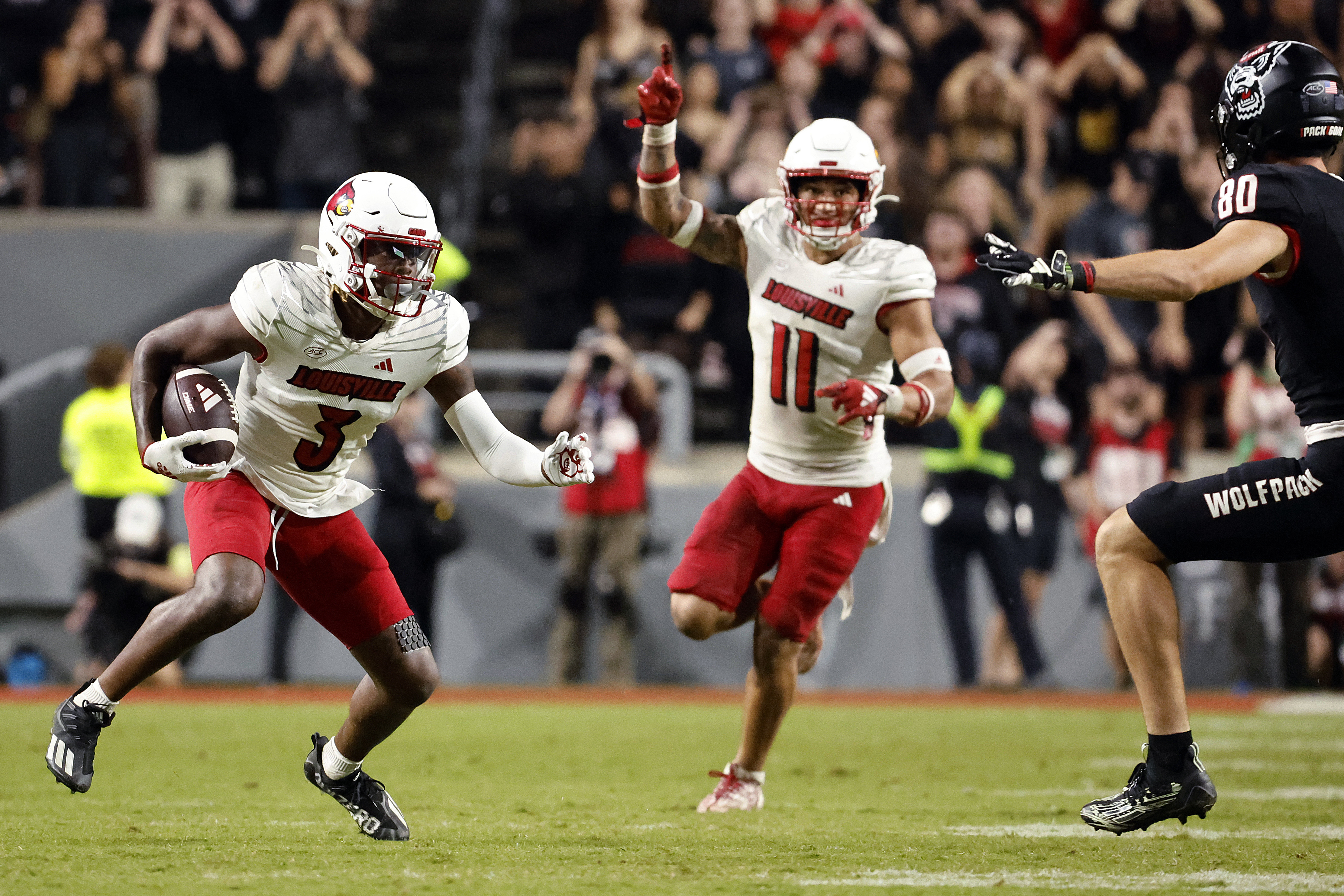 FILE - Louisville's Quincy Riley (3) runs with an interception as Cam'Ron Kelly (11) directs the return with North Carolina State's Bradley Rozner (80) defending during the second half of an NCAA college football game in Raleigh, N.C., Friday, Sept. 29, 2023. 