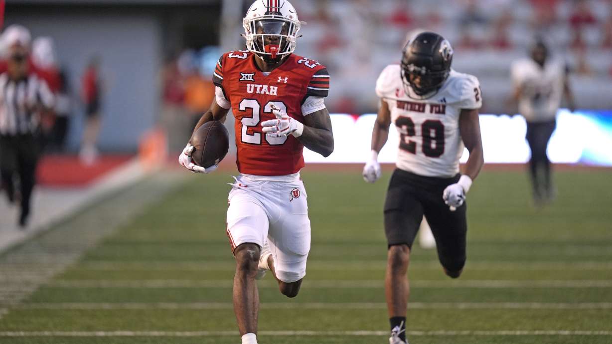 Utah running back Dijon Stanley (23) outruns Southern Utah safety Kameron Rocha (28) as he carries the ball for a touchdown in the first half of an NCAA college football game Thursday, Aug. 29, 2024, in Salt Lake City.