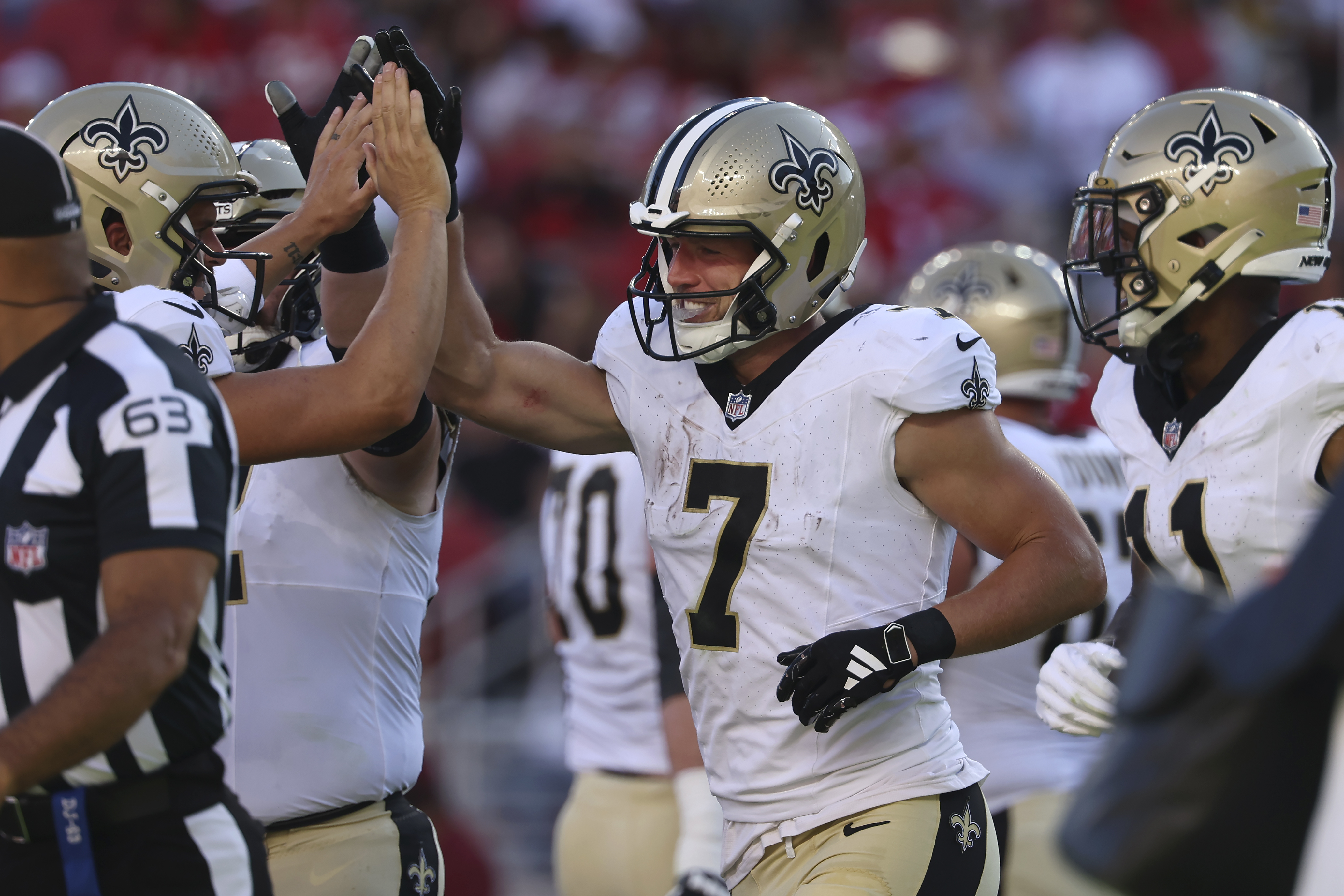New Orleans Saints' Taysom Hill (7) is congratulated by teammates after scoring against the San Francisco 49ers during the first half of a preseason NFL football game in Santa Clara, Calif., Sunday, Aug. 18, 2024. 
