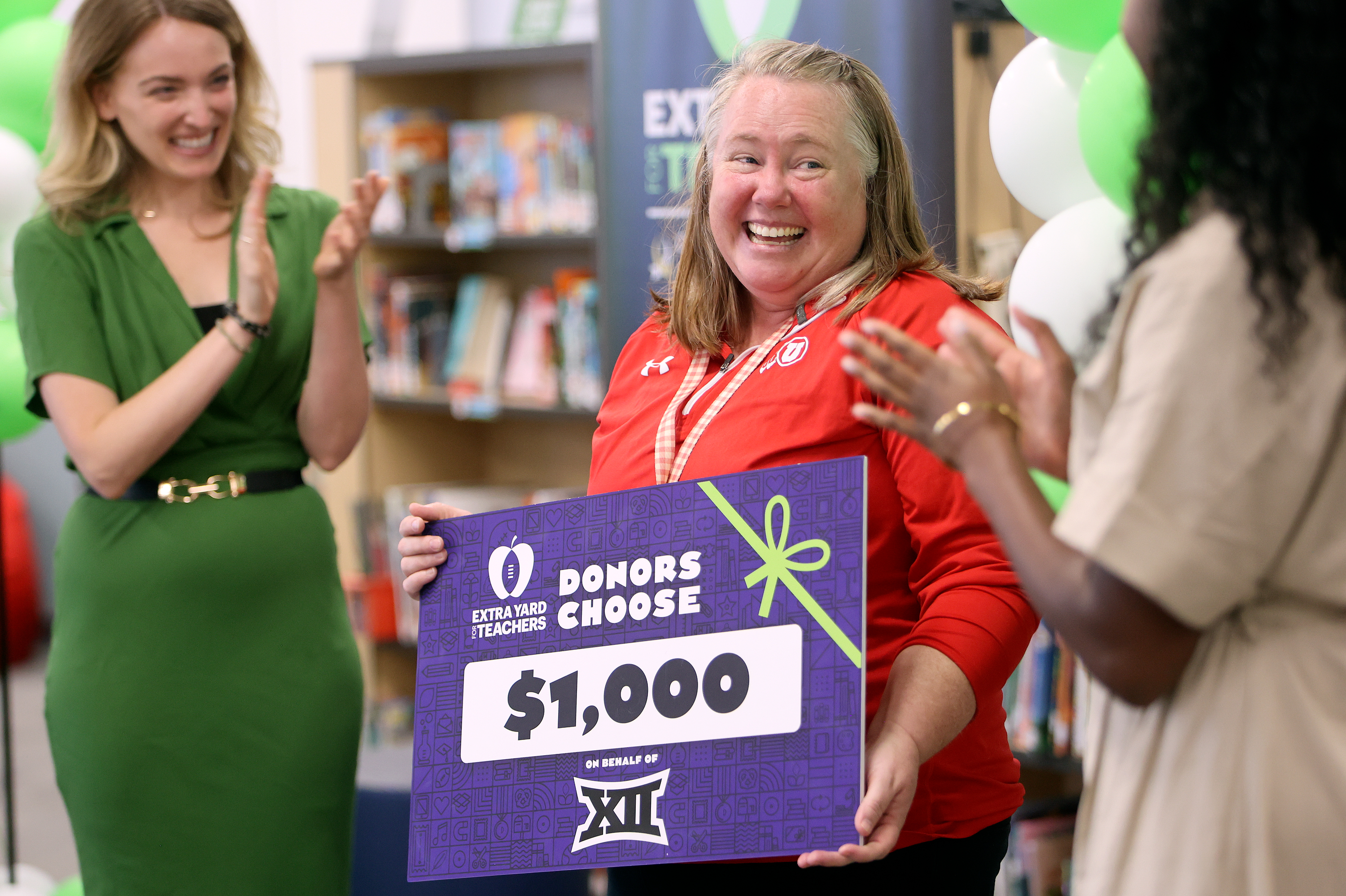 First grade teacher Tiffany Otterstrom reacts as she is given $1,000 to spend on her classroom during an event to unveil Newman Elementary’s newly renovated library at Newman Elementary in Salt Lake City on Thursday. The upgrades were made possible by the College Football Playoff Foundation, Big 12 Conference, School Specialty and University of Utah.