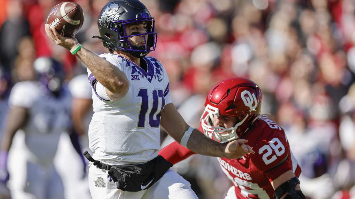 FILE - TCU quarterback Josh Hoover (10) passes under pressure by Oklahoma linebacker Danny Stutsman (28) during the first half of an NCAA college football game Friday, Nov. 24, 2023, in Norman, Okla.