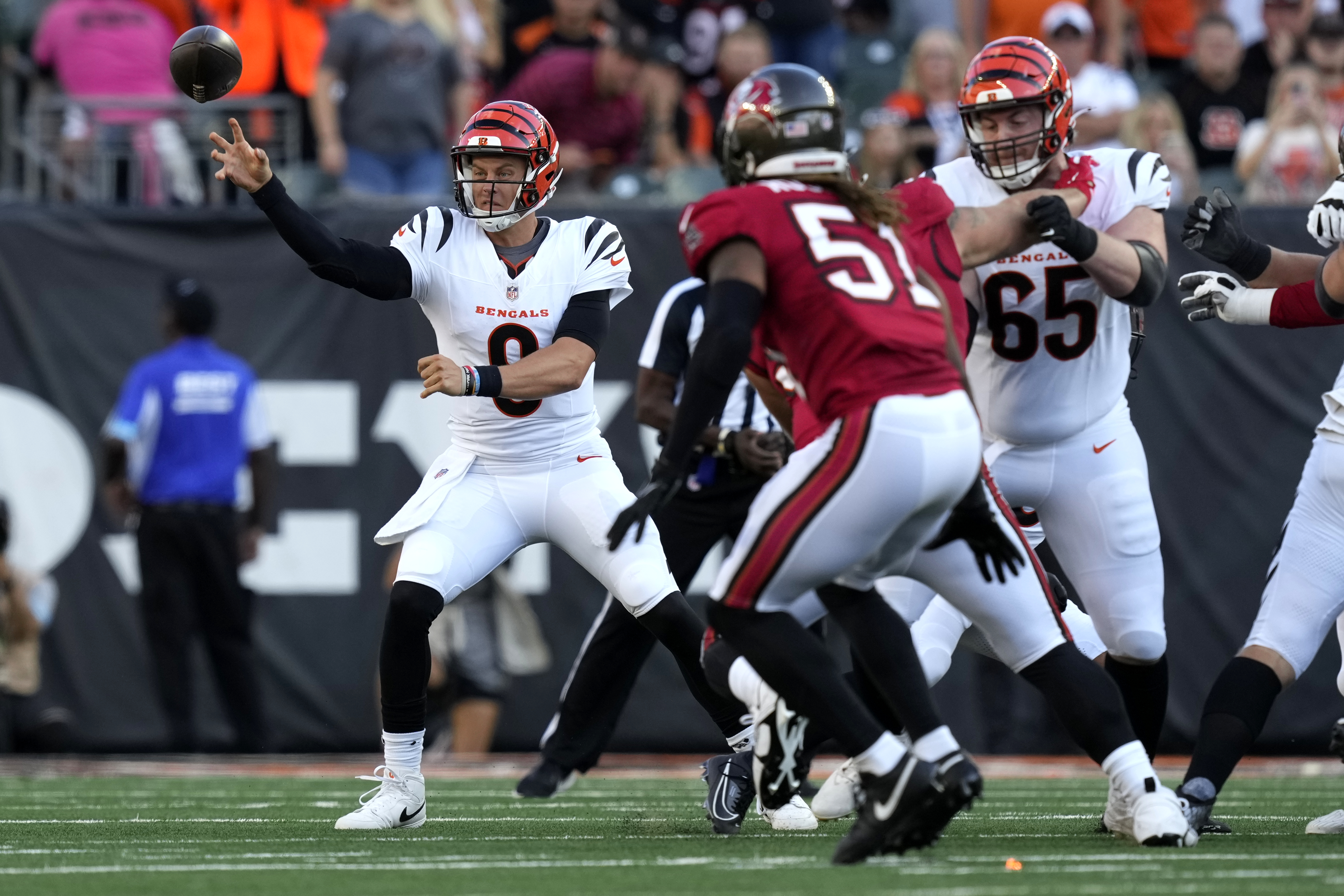 Cincinnati Bengals quarterback Joe Burrow (9) gets a pass away as Tampa Bay Buccaneers linebacker J.J. Russell (51) defends in the first half of an NFL preseason football game Saturday, Aug. 10, 2024, in Cincinnati. 
