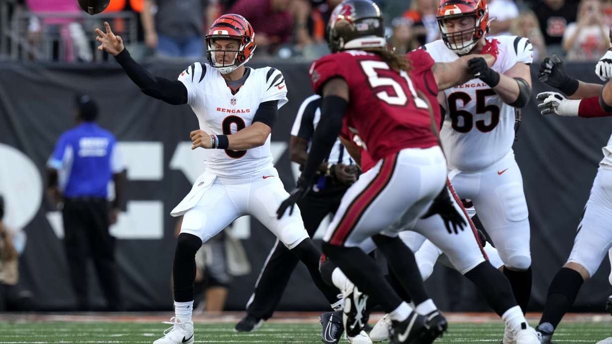 Cincinnati Bengals quarterback Joe Burrow (9) gets a pass away as Tampa Bay Buccaneers linebacker J.J. Russell (51) defends in the first half of an NFL preseason football game Saturday, Aug. 10, 2024, in Cincinnati.