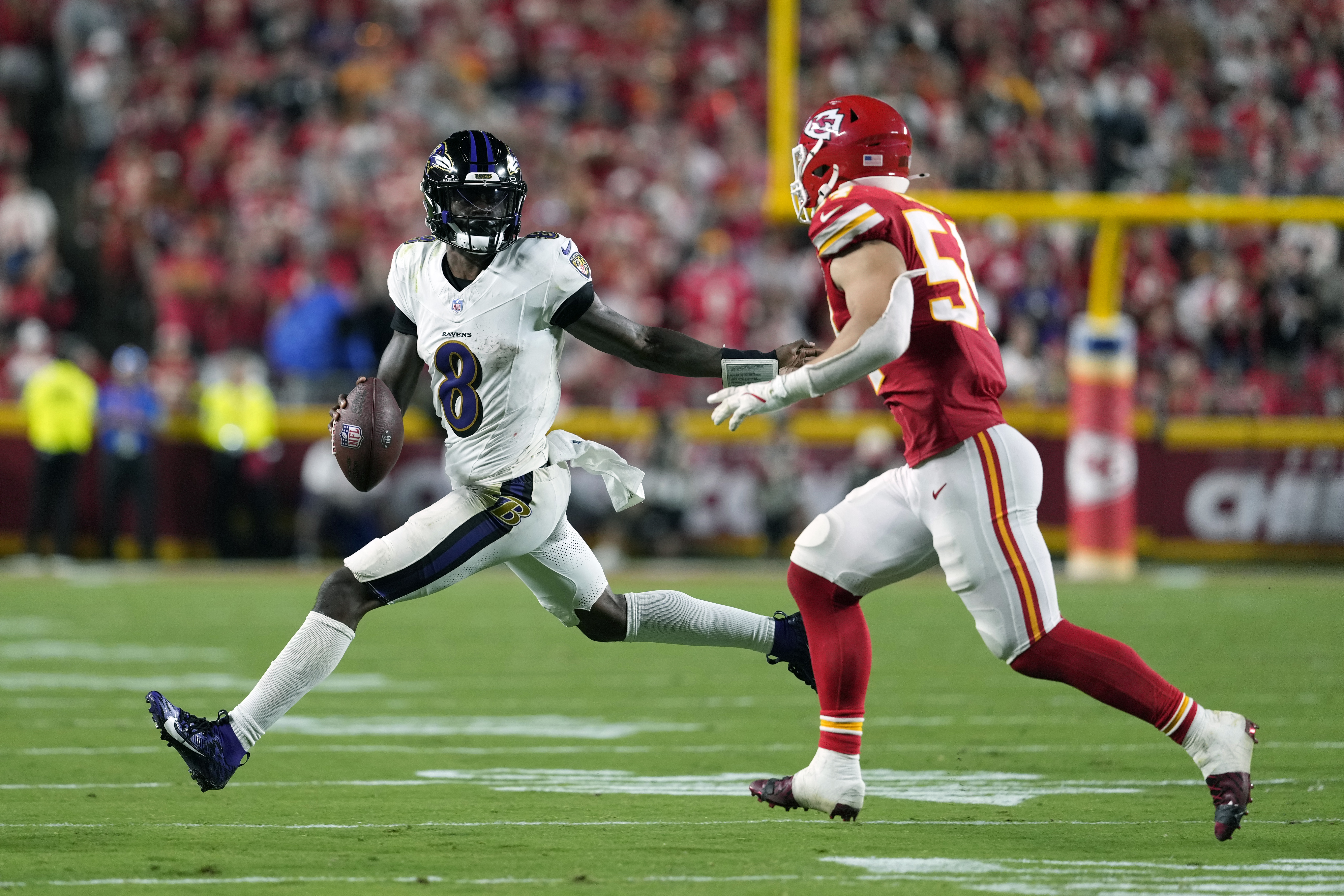 Baltimore Ravens quarterback Lamar Jackson (8) scrambles as Kansas City Chiefs linebacker Leo Chenal defends during the second half of an NFL football game Thursday, Sept. 5, 2024, in Kansas City, Mo.