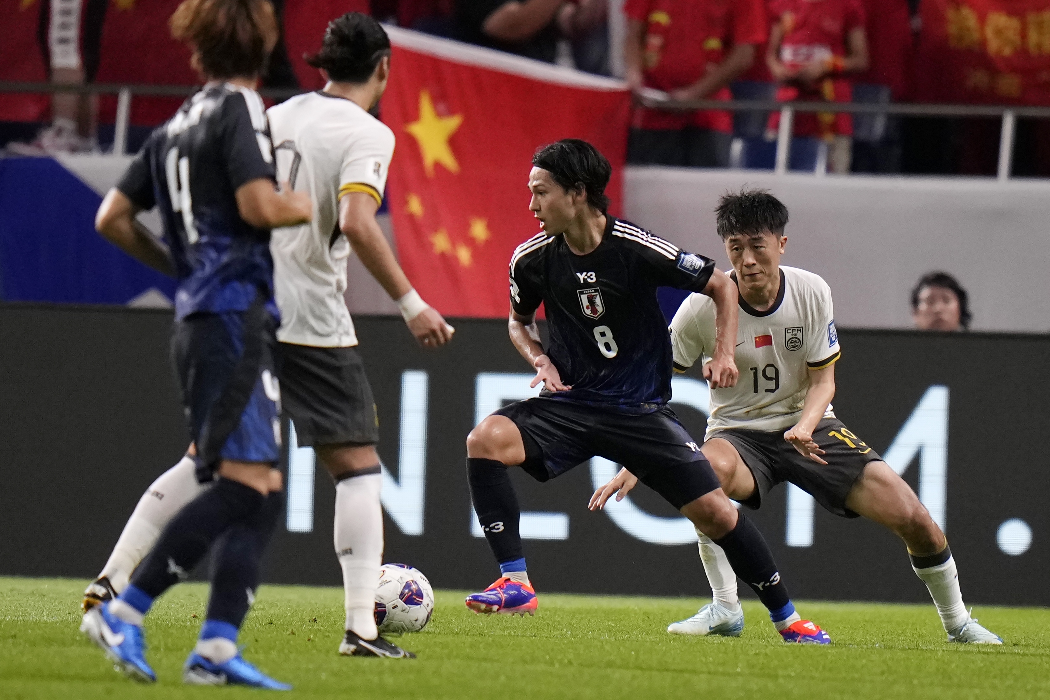 Japan's Takumi Minamino and China's Liu Yangyi compete for the ball during a World Cup and AFC Asian Qualifier between Japan and China at Saitama Stadium 2002 in Saitama, north of Tokyo, Thursday, Sept. 5, 2024.