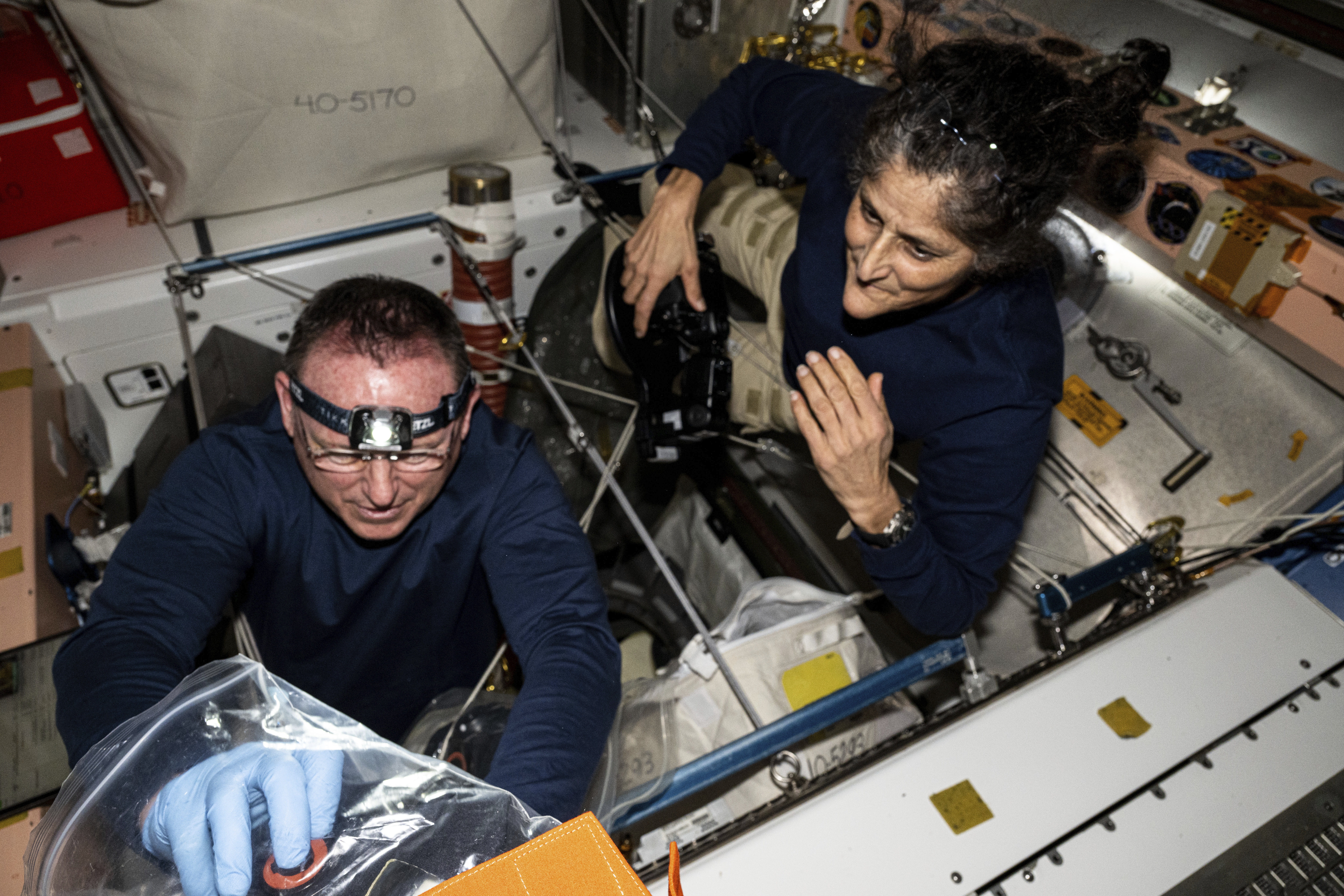In this photo provided by NASA, astronauts Butch Wilmore, left, and Suni Williams inspect safety hardware aboard the International Space Station on Aug. 9.