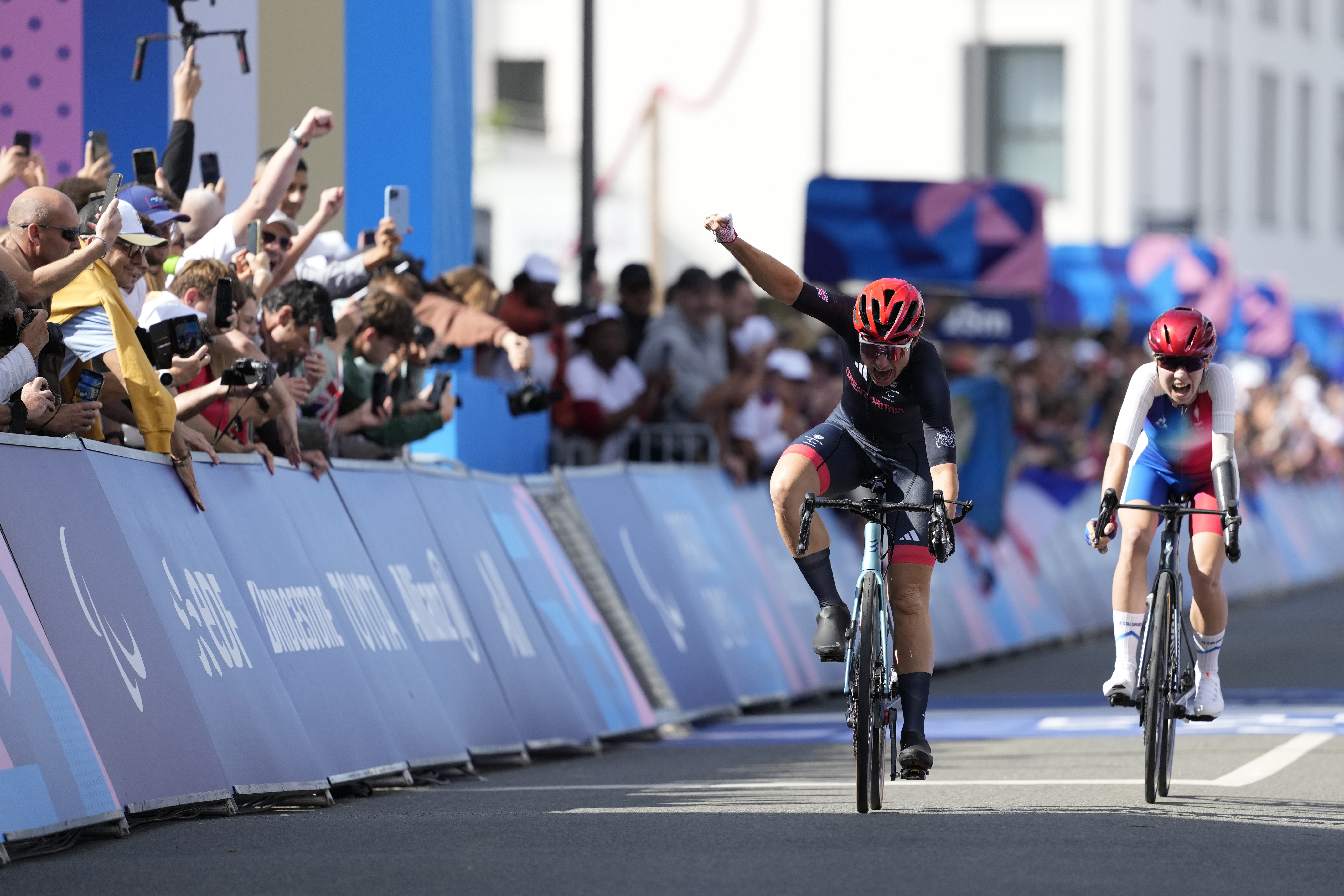 Britain's Sarah Storey, left, celebrates as she wins the gold medal in the women's C4-5 road race during the 2024 Paralympics, Friday, Sept. 6, 2024, in Clichy-sous-Bois, France.