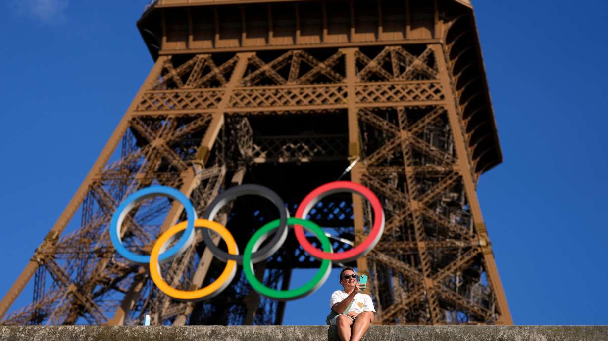 A man takes a selfie with the Olympic rings on the Eiffel Tower during the 2024 Summer Olympics, Aug. 6, in Paris, France.
