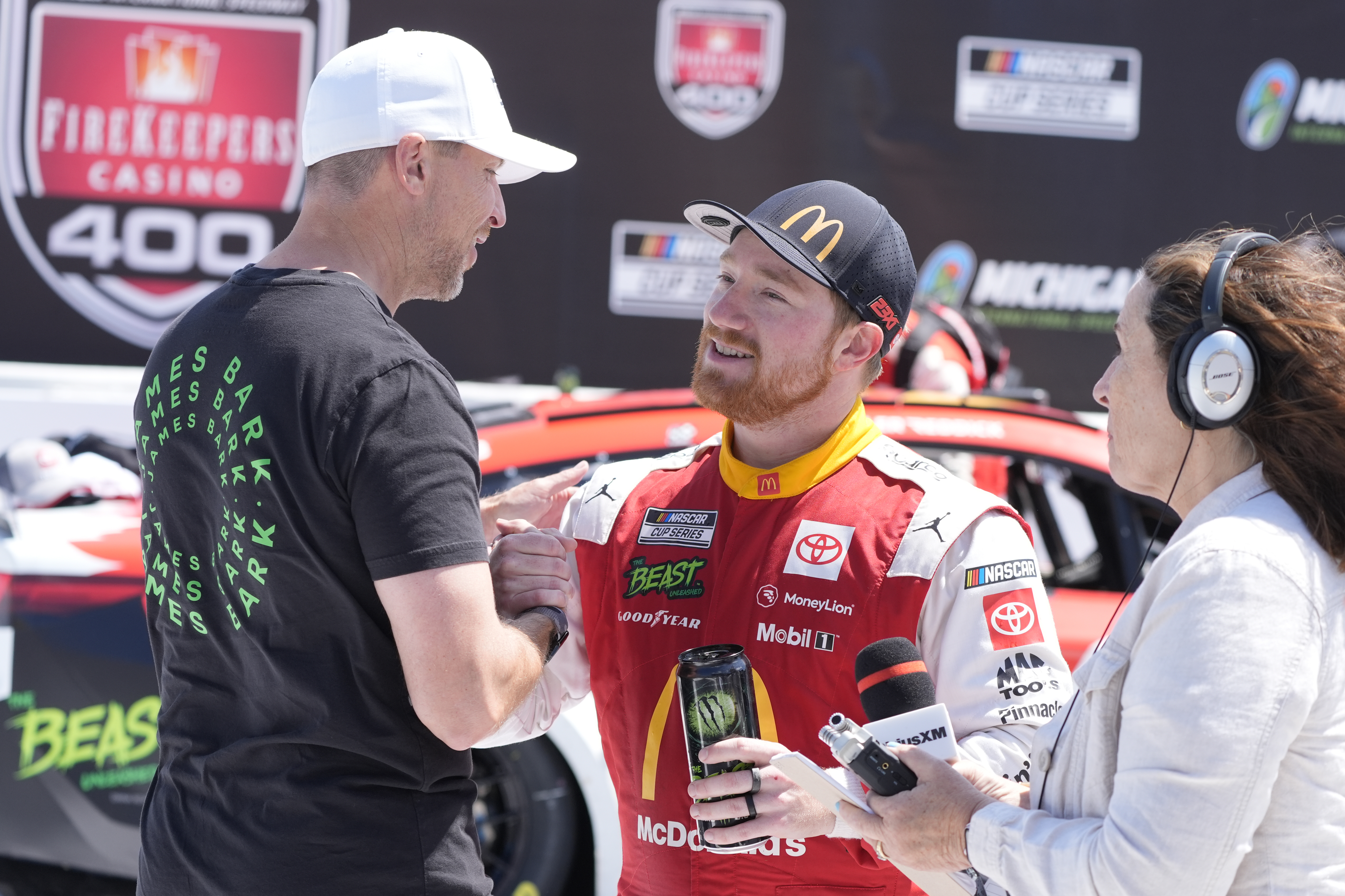 Tyler Reddick is greeted by Denny Hamlin after winning a NASCAR Cup Series auto race at Michigan International Speedway, Monday, Aug. 19, 2024, in Brooklyn, Mich.