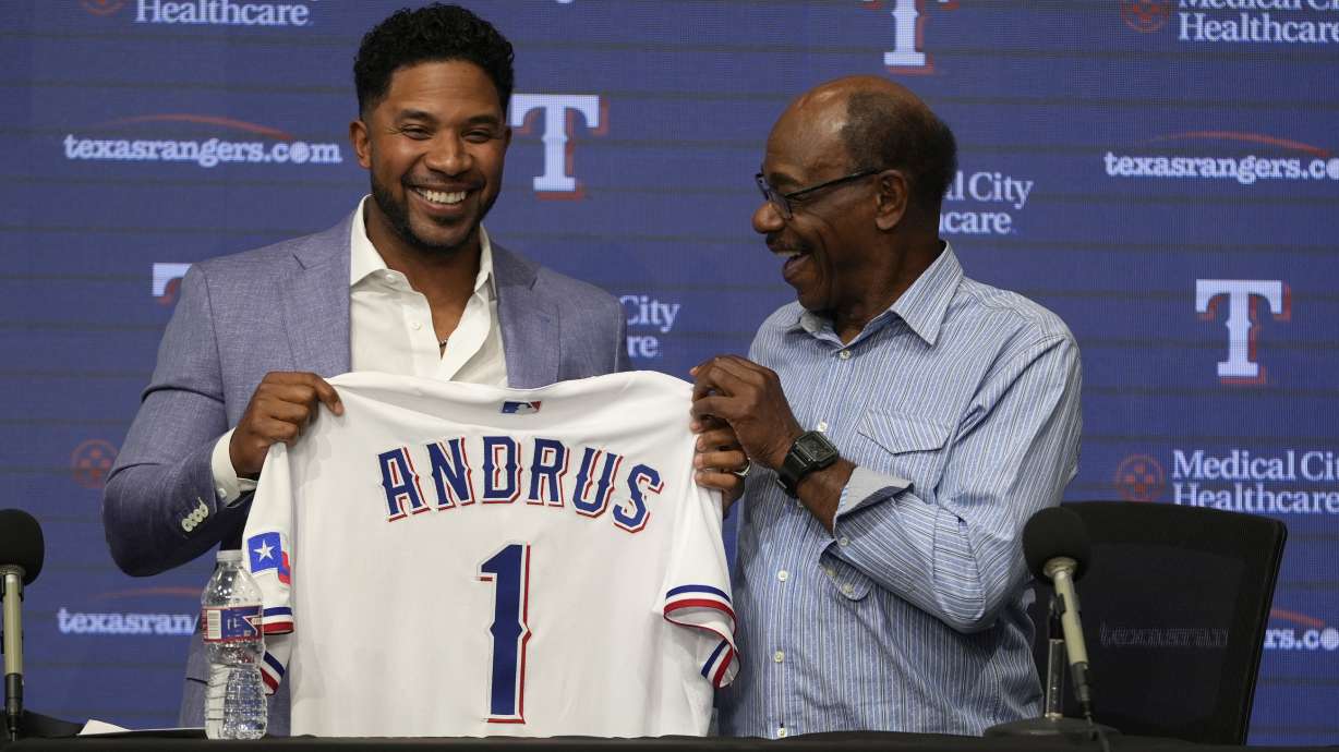 Texas Rangers' Elvis Andrus, left, smiles with Los Angeles Angels Manager Ron Washington after Andrus signed a one-day contract with the Rangers during a news conference before the baseball game between the Rangers and the Los Angeles Angels, Friday, Sept. 6, 2024, in Arlington, Texas. Andrus announced his retirement as an active Texas Rangers player after playing the first 12 seasons of his 15-year Major League career in Arlington.