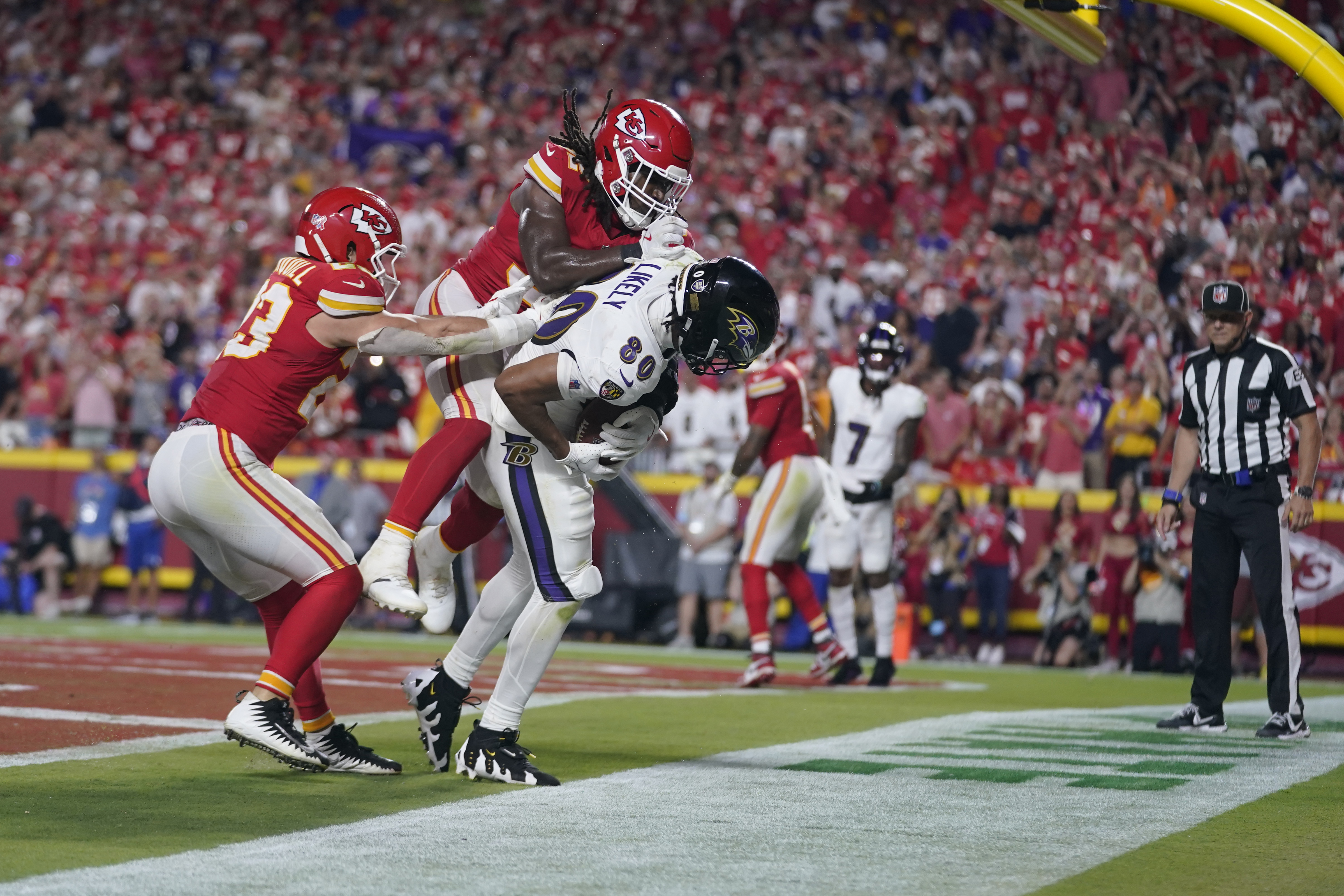 Baltimore Ravens tight end Isaiah Likely (80) catches a pass with his toe out of bounds as Kansas City Chiefs linebacker Nick Bolton and linebacker Drue Tranquill, left, defend as time time expires in the second half of an NFL football game Thursday, Sept. 5, 2024, in Kansas City, Mo. The Chiefs won 27-20.
