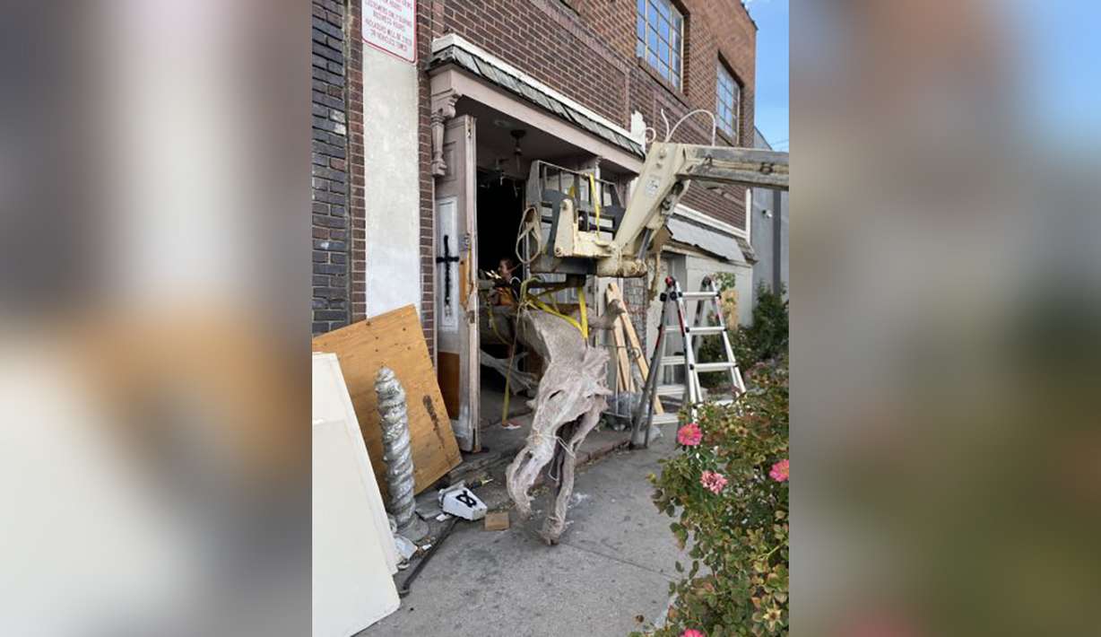 Volunteers work to remove a 2,000-pound concrete serpent from the Christian School in Salt Lake City.