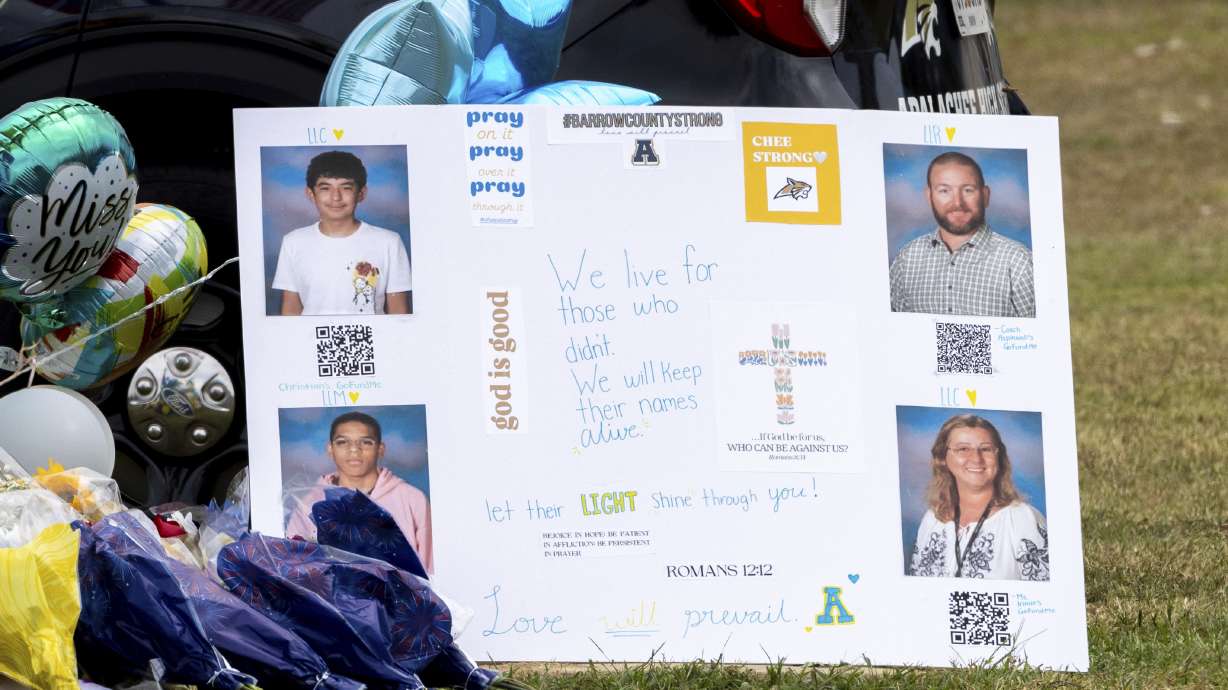 A poster with images of victims Christian Angulo, top left, Richard Aspinwall, top right, Mason Schermerhorn, bottom left, and Cristina Irimie is displayed at a memorial outside Apalachee High School, Friday, in Winder, Ga., following a shooting at the school earlier in the week.