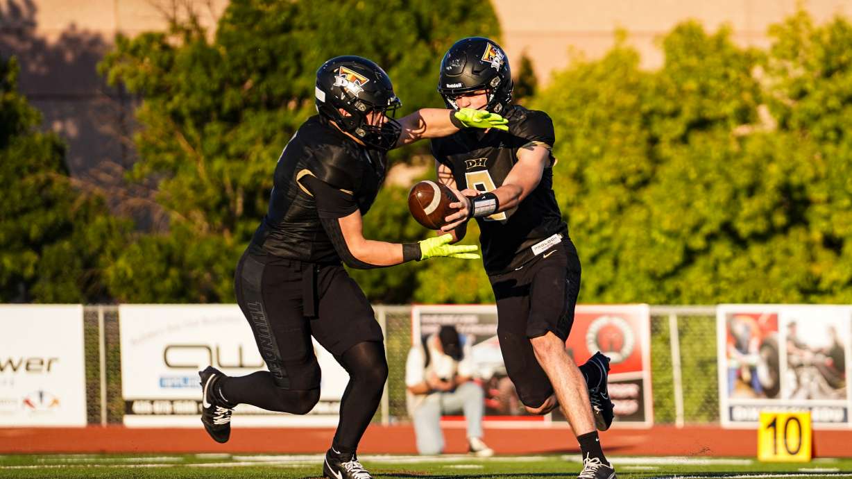 Desert Hills' Gerritt Grondel hands off to Tytan Mason.