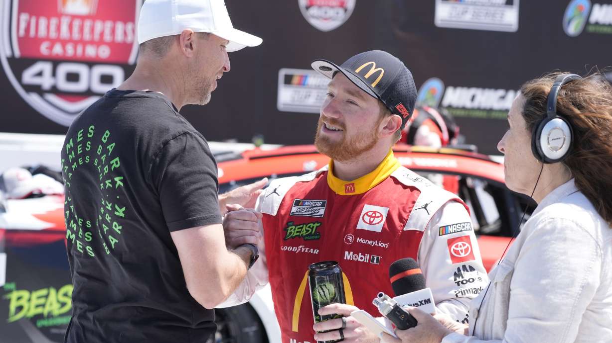 Tyler Reddick is greeted by Denny Hamlin after winning a NASCAR Cup Series auto race at Michigan International Speedway, Monday, Aug. 19, 2024, in Brooklyn, Mich.