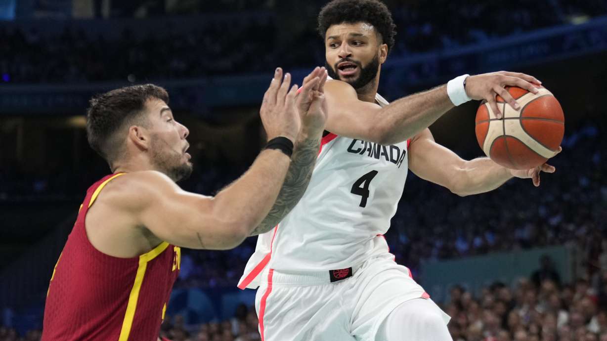 FILE - Jamal Murray, right, of Canada, looks to pass the ball around Willy Hernangomez, left, of Spain, in a men's basketball game at the 2024 Summer Olympics, Aug. 2, 2024, in Villeneuve-d'Ascq, France.