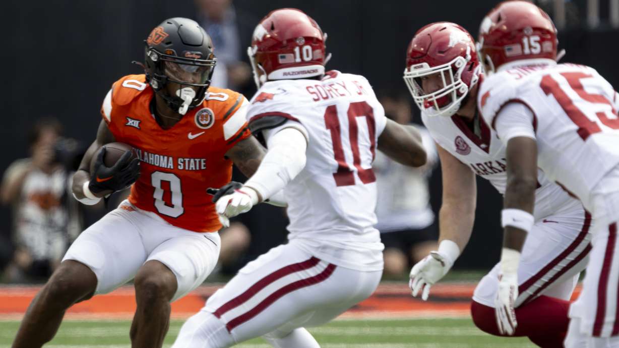 Oklahoma State running back Ollie Gordon II (0) runs into Arkansas linebacker Xavian Sorey Jr. (10) and others in the first half of an NCAA college football game Saturday, Sept. 7, 2024, in Stillwater, Okla.